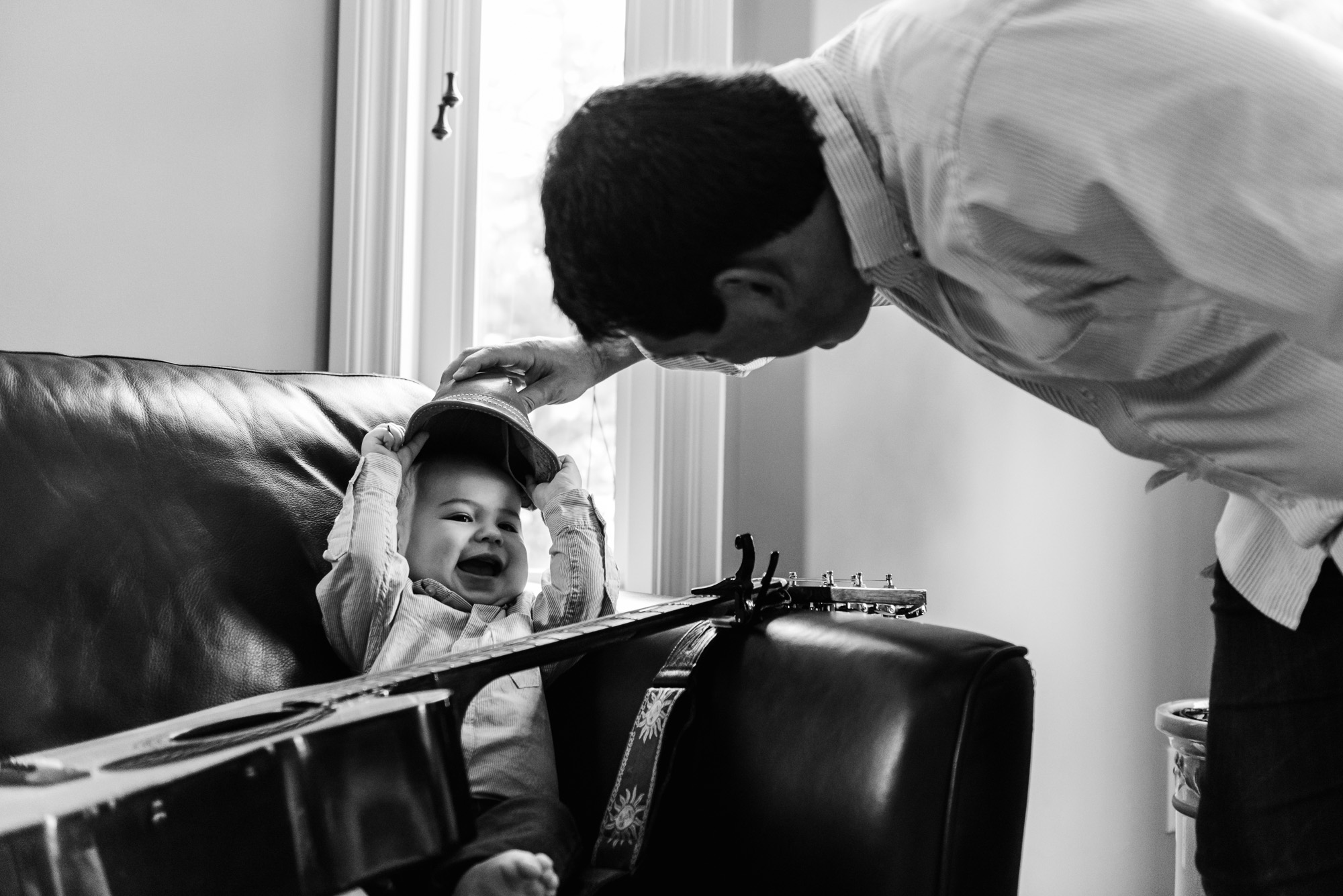 A dad plays with his son with a guitar and hat. Baby Photographers Edmonton