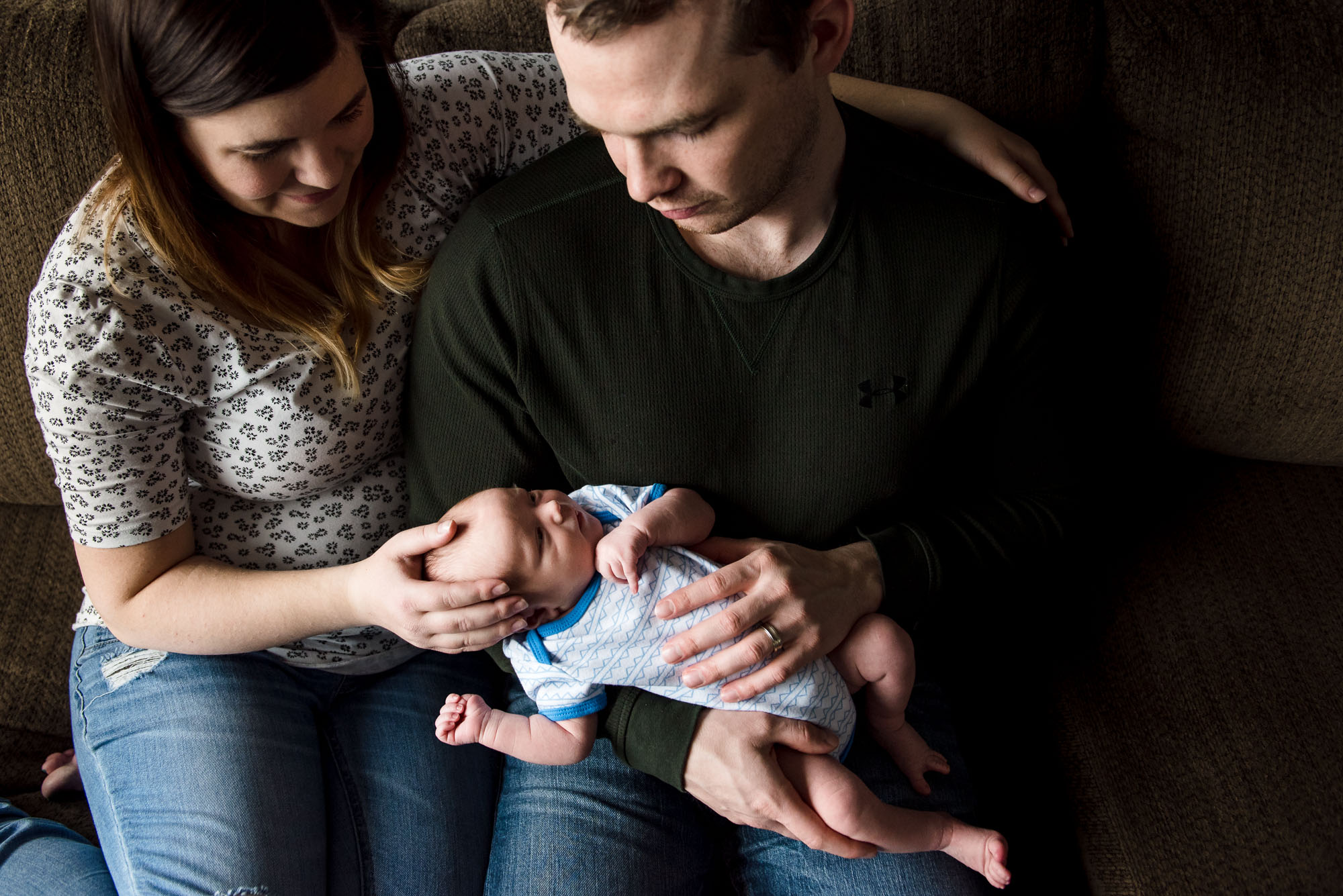 New parents stare down adoringly at their newborn baby boy in their Sherwood Park home. 
