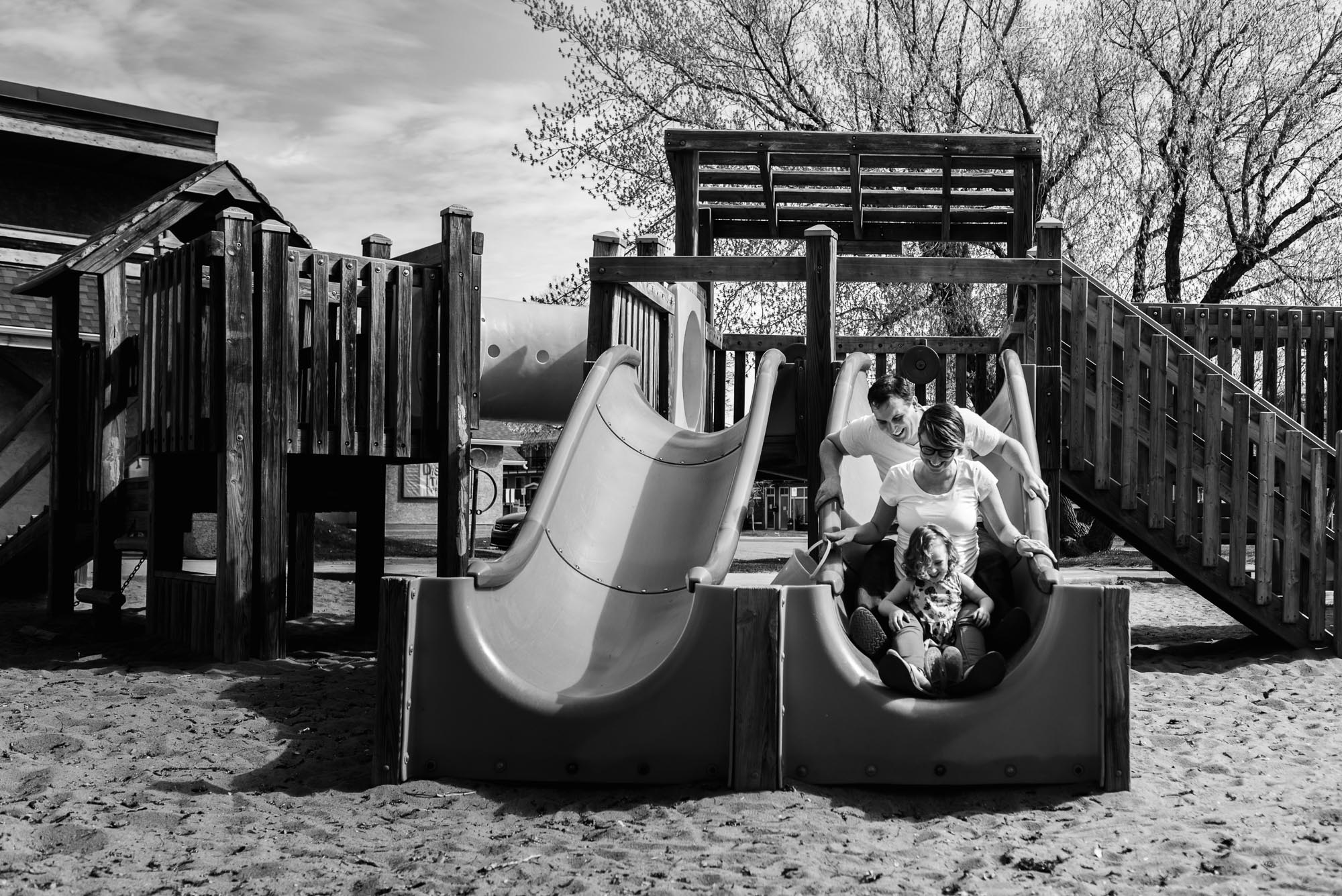 a family slides down a playground slide in Westmount, Edmonton