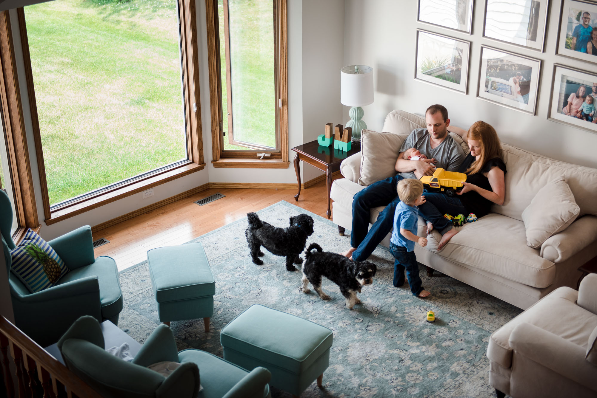 A family hangs out in their Sherwood Park, Alberta living room with their son and newborn baby