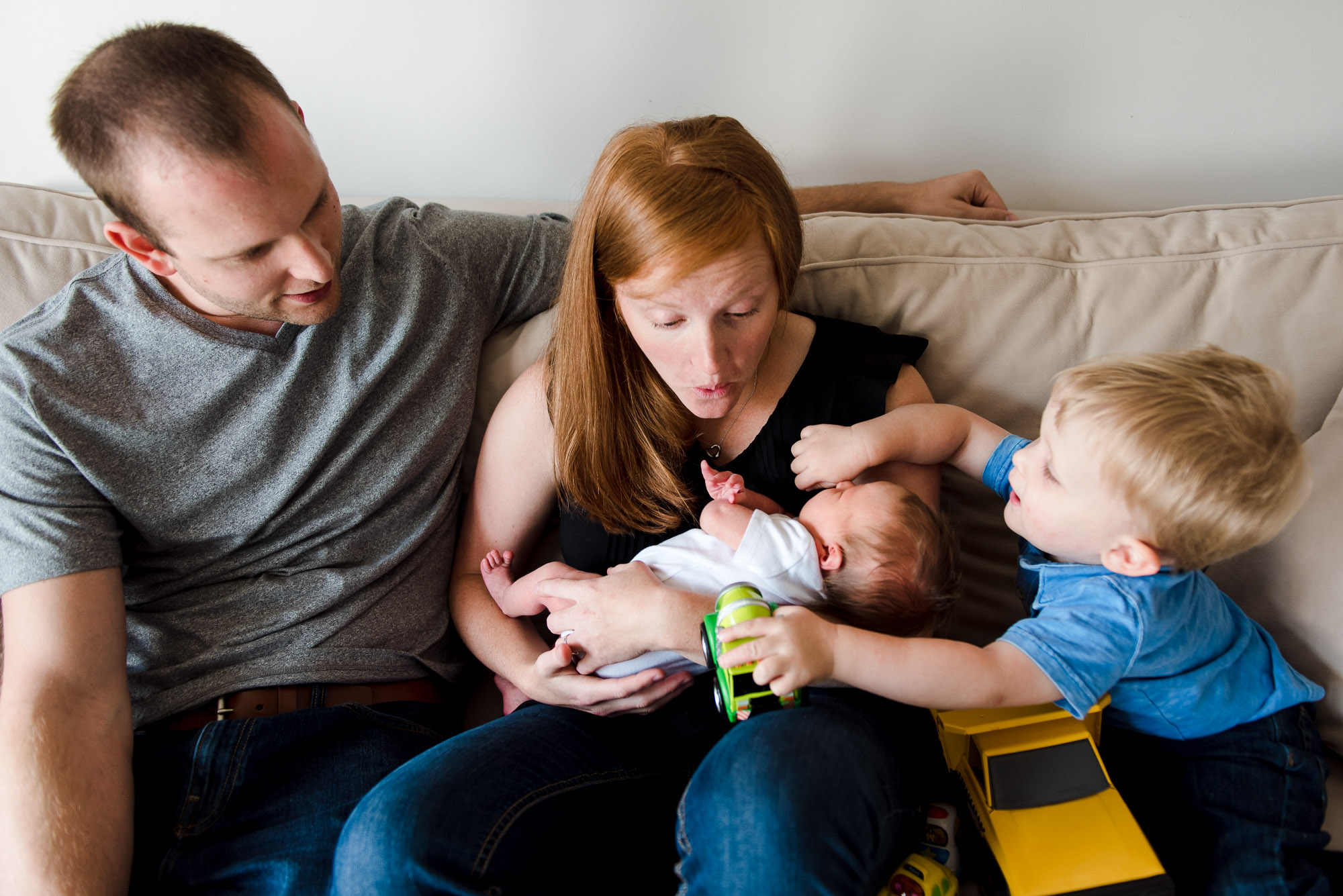 A sherwood Park family sits with their newborn baby daugthter