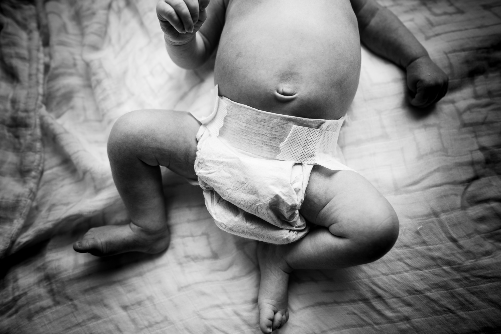 A close up detail of a baby belly button during an in-home lifestyle newborn photo session