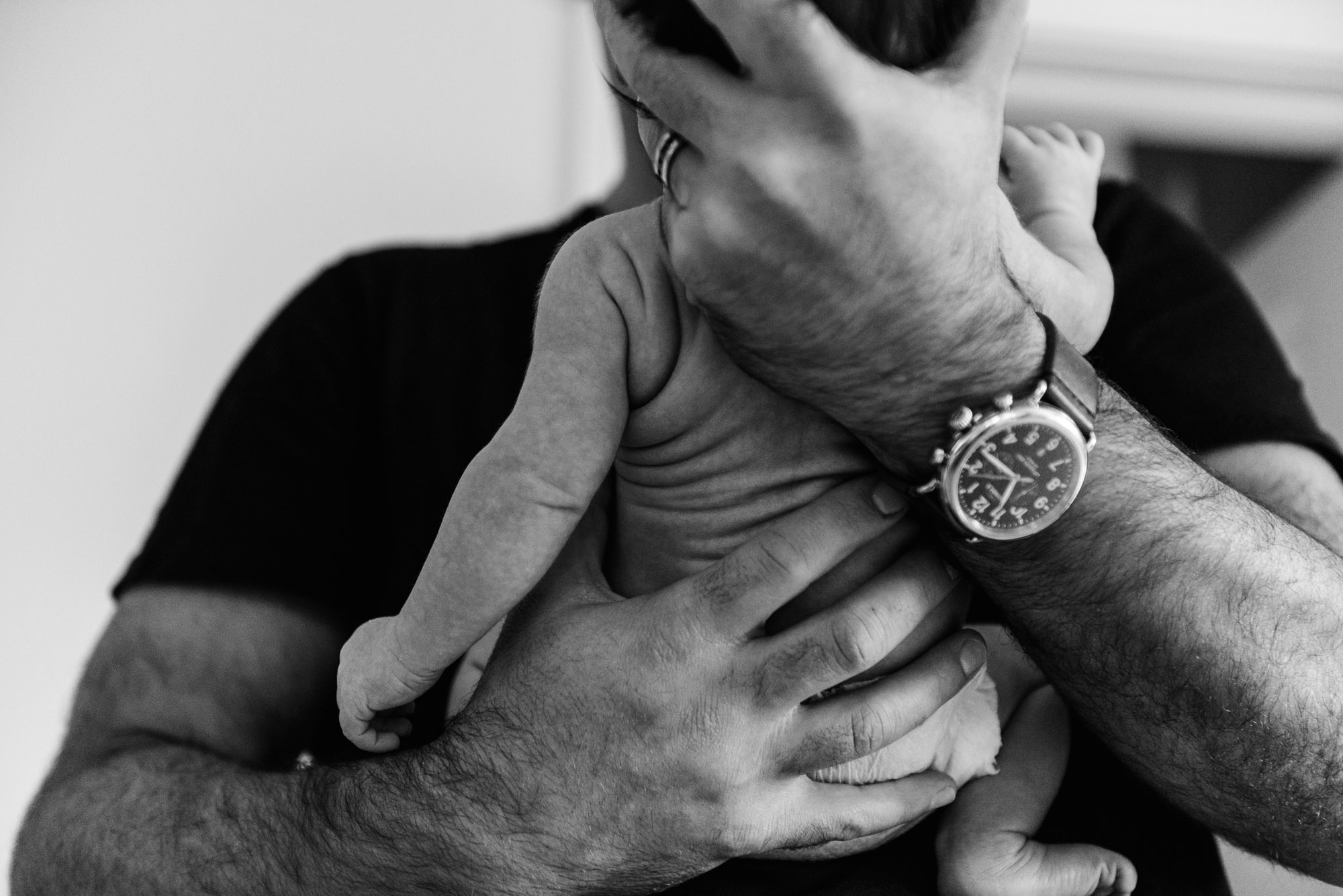 Baby back wrinkles form a dad holds is newborn baby girl. By newborn baby photographer Fiddle Leaf Photography.