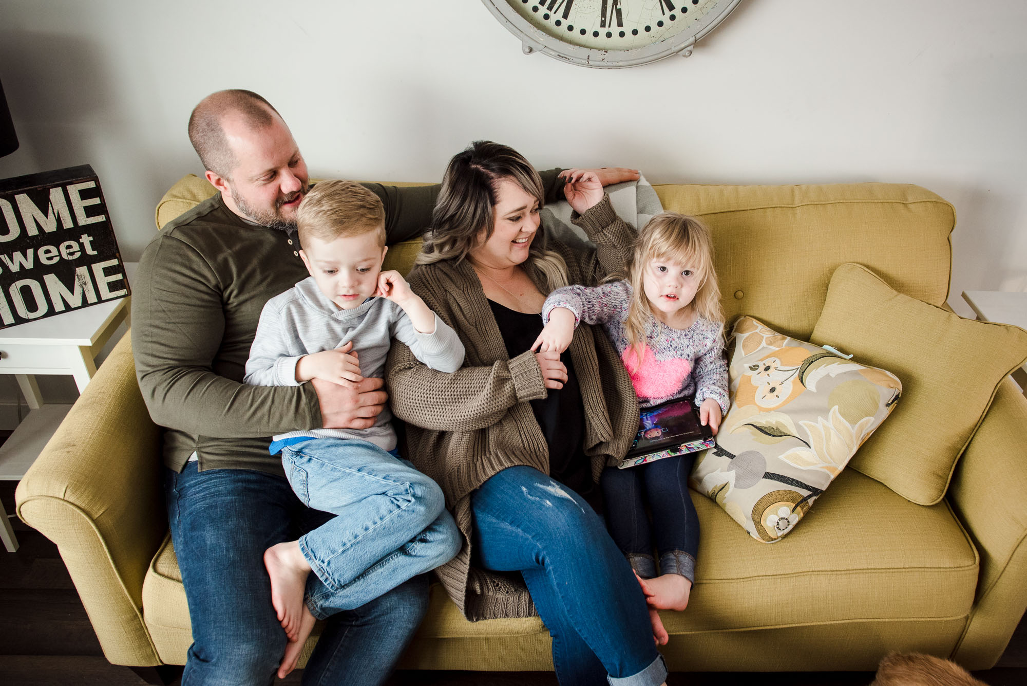 A family hangs out on their couch during a casual family photo session in sherwood park