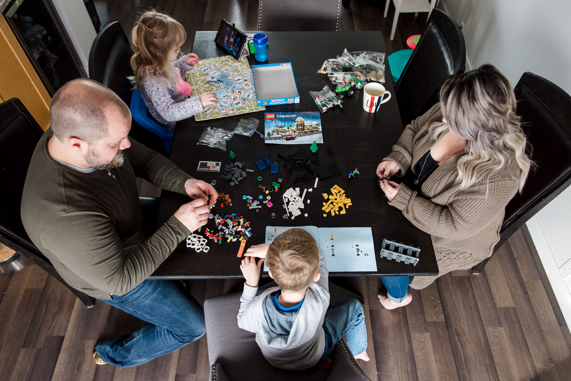 Casual family photographer Fiddle Leaf Photography captures a family building lego at their kitchen table. 