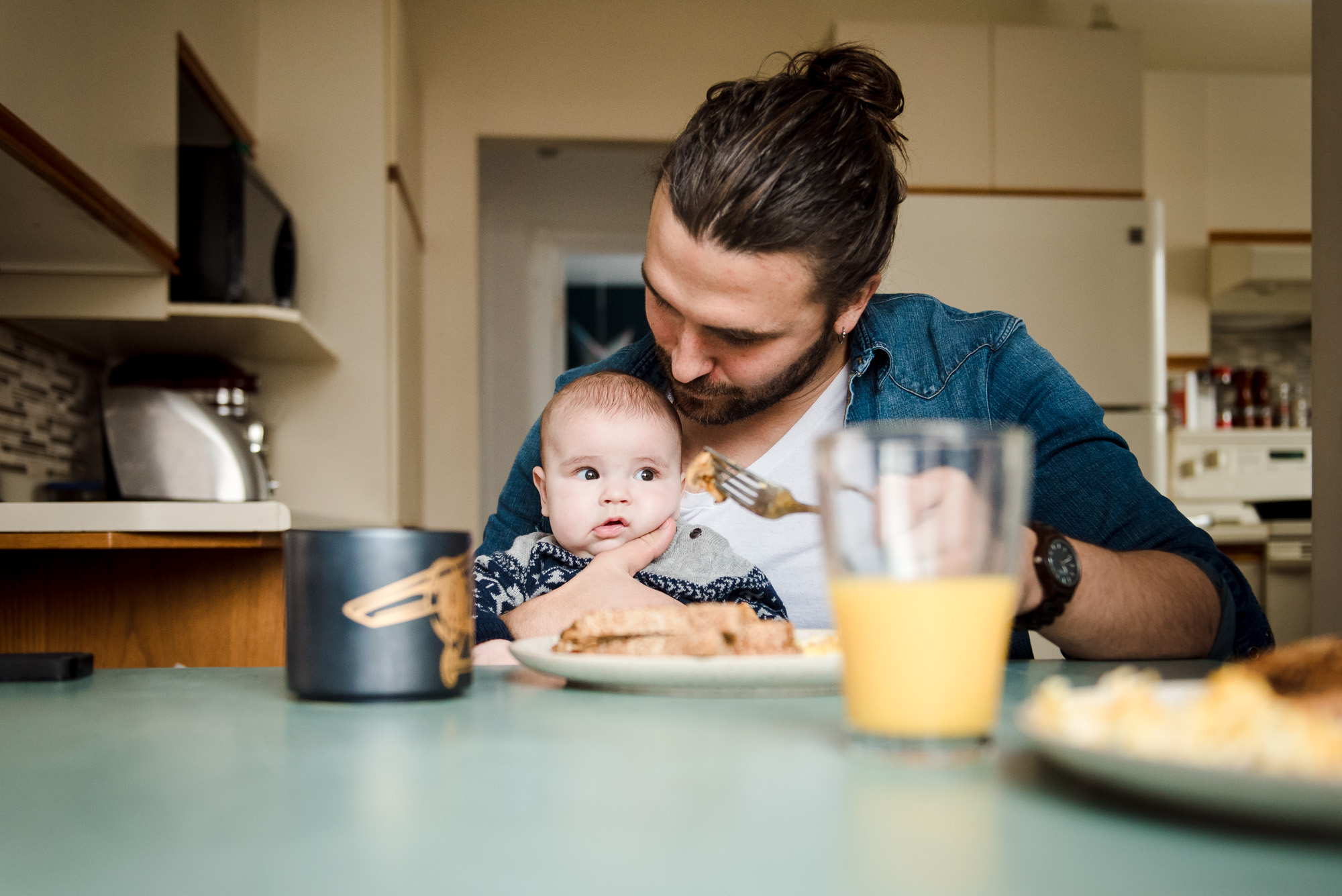 A dad eats breakfast with his baby boy in their Fort Saskatchewan home