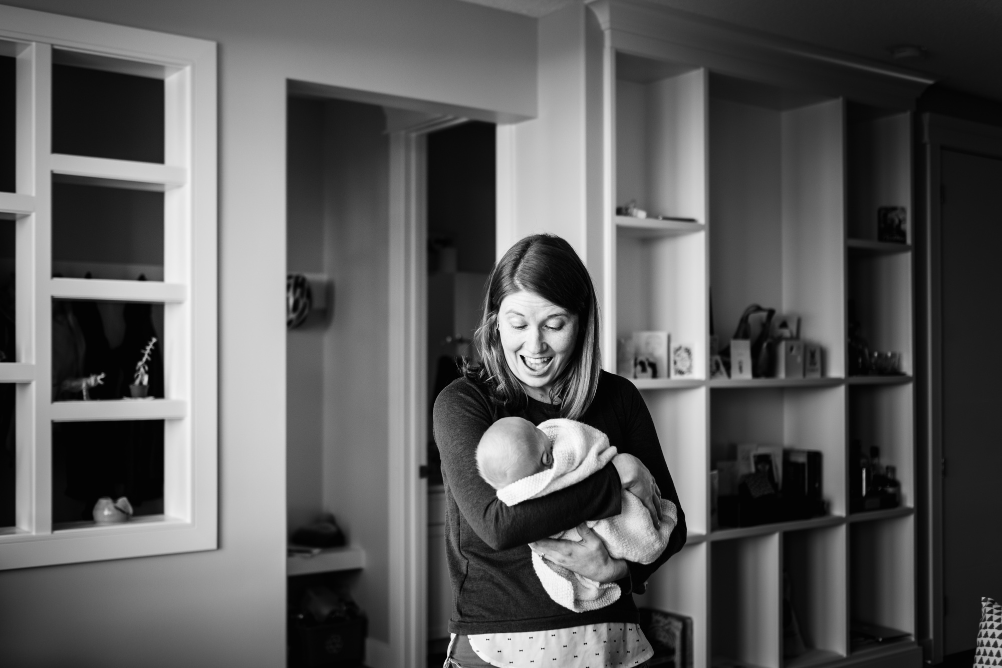 A mom smiles at her newborn baby boy in her Edmonton photo session by Fiddle Leaf Photography