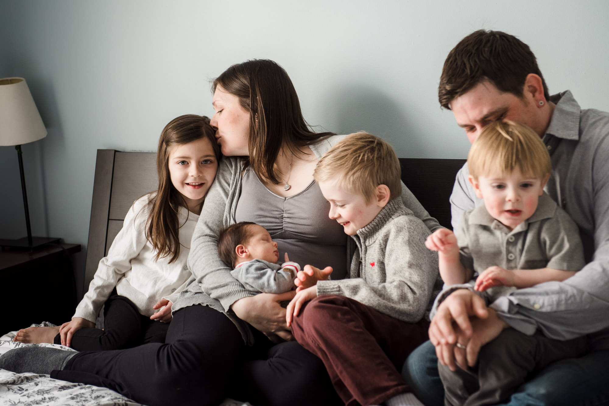 A casual family portrait as part of a lifestyle edmonton newborn photo session featuring 4 siblings and praents. 