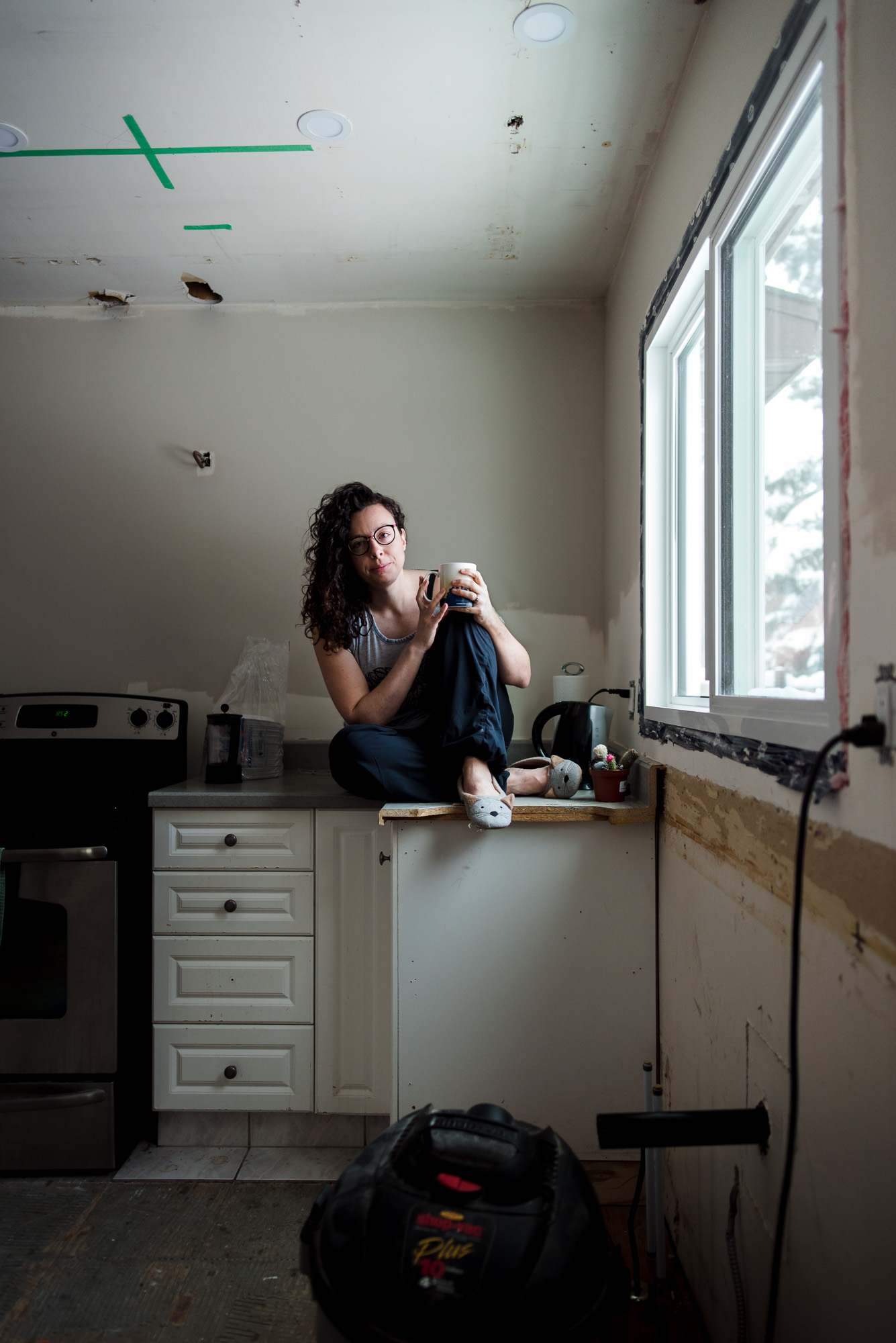 A woman sits in her kitchen that is under renovation. Edmonton renovations