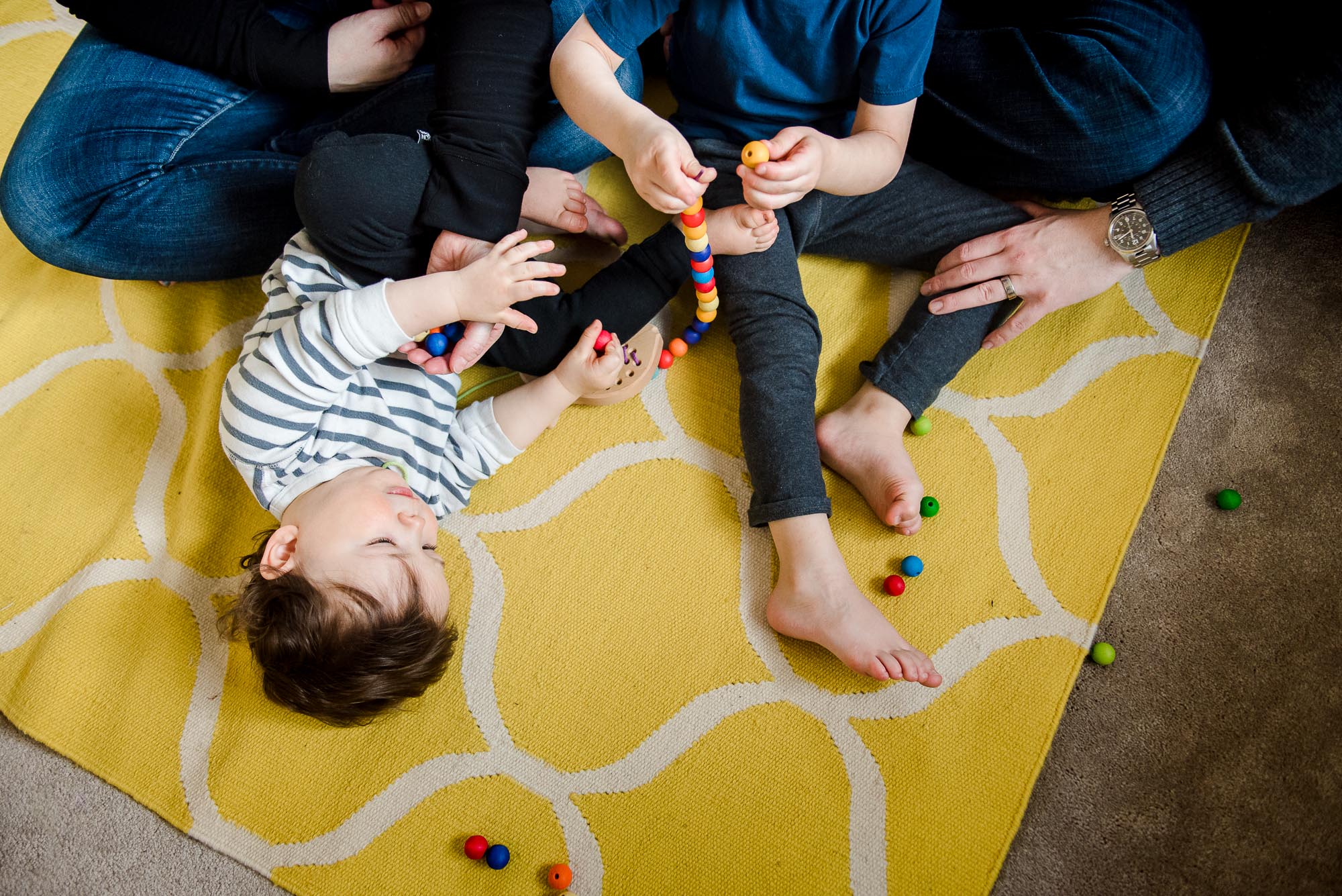 A family plays on a carpet together during their Edmonton family photo session 