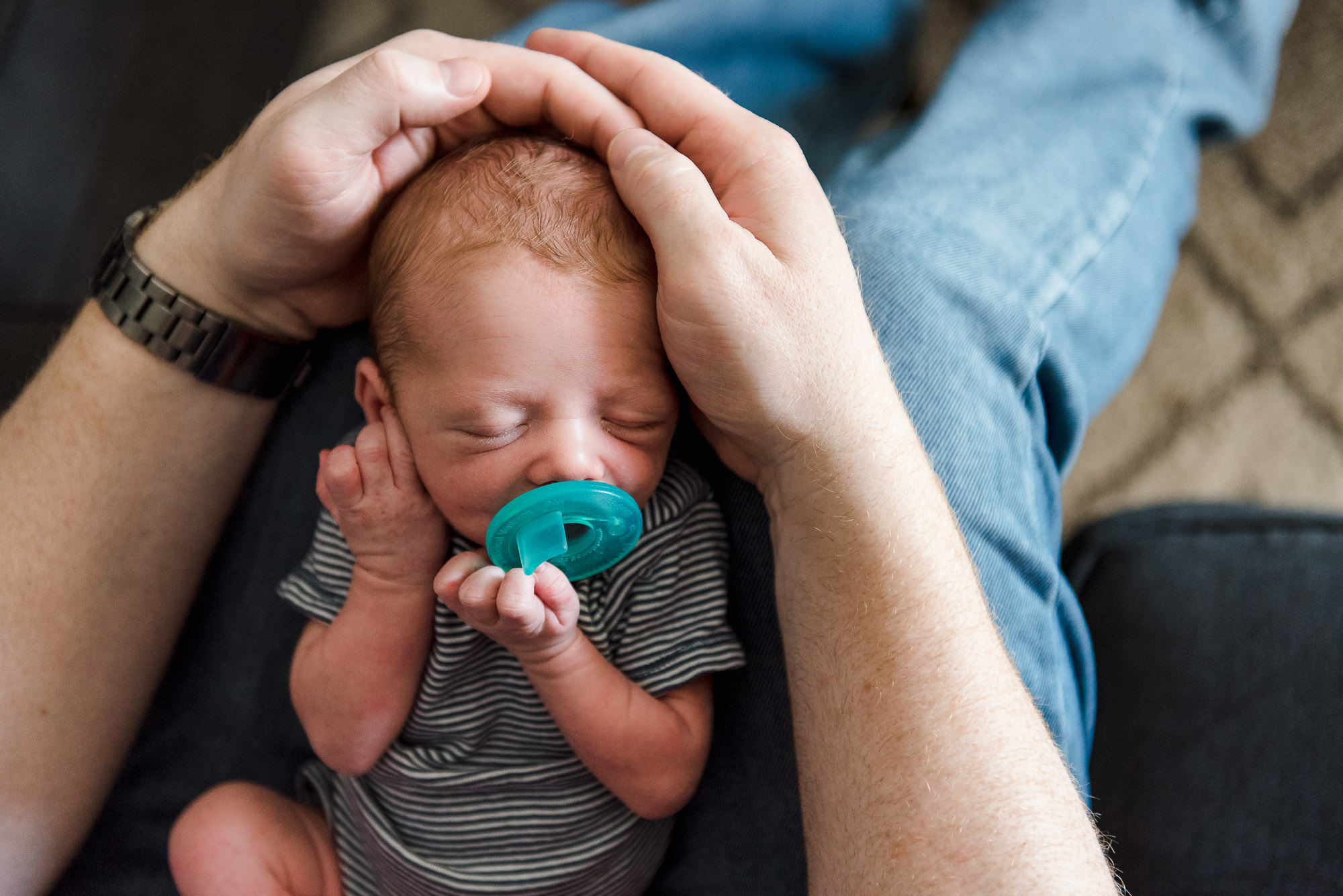 A Dad clasps his son's head tenderly with his hands by Edmonton Photographer Kelly Marleau