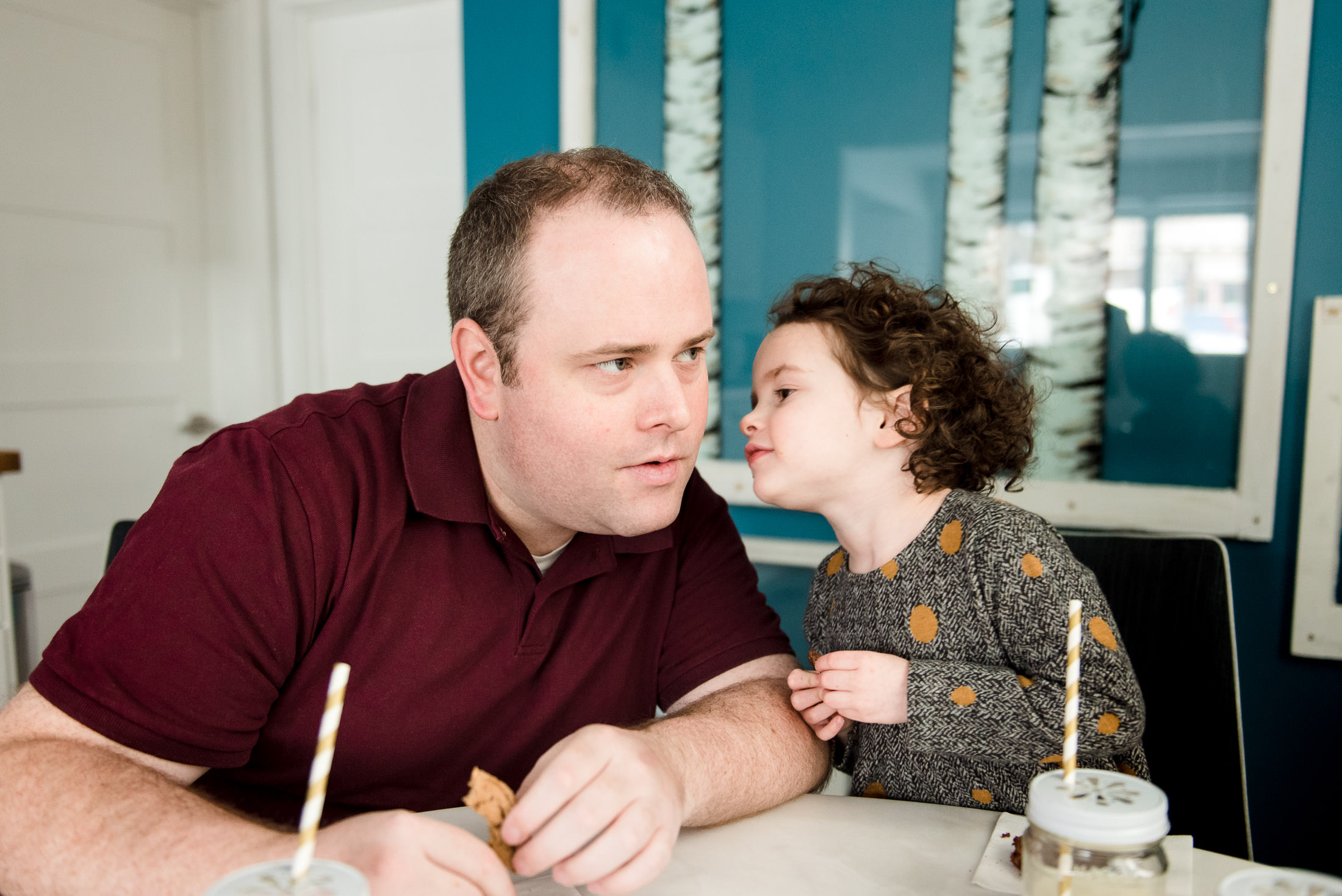 A little girl whispers to her dad