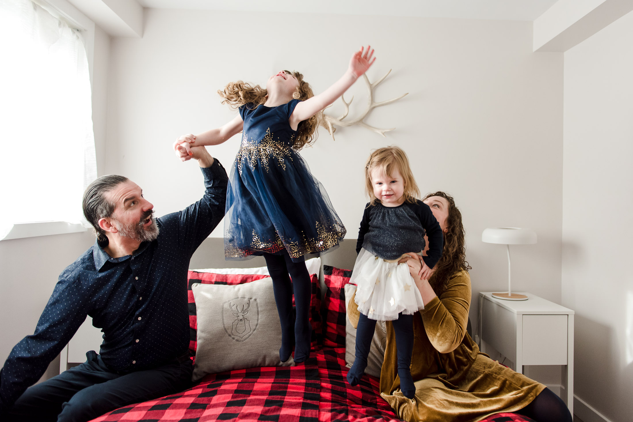 Kids jump on the bed during mini sessions by Edmonton family photographer Fiddle Leaf Photography