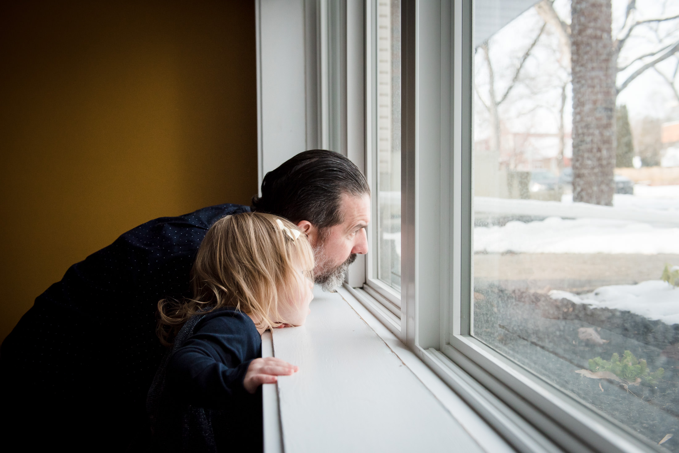 A dad and daughter look out the window