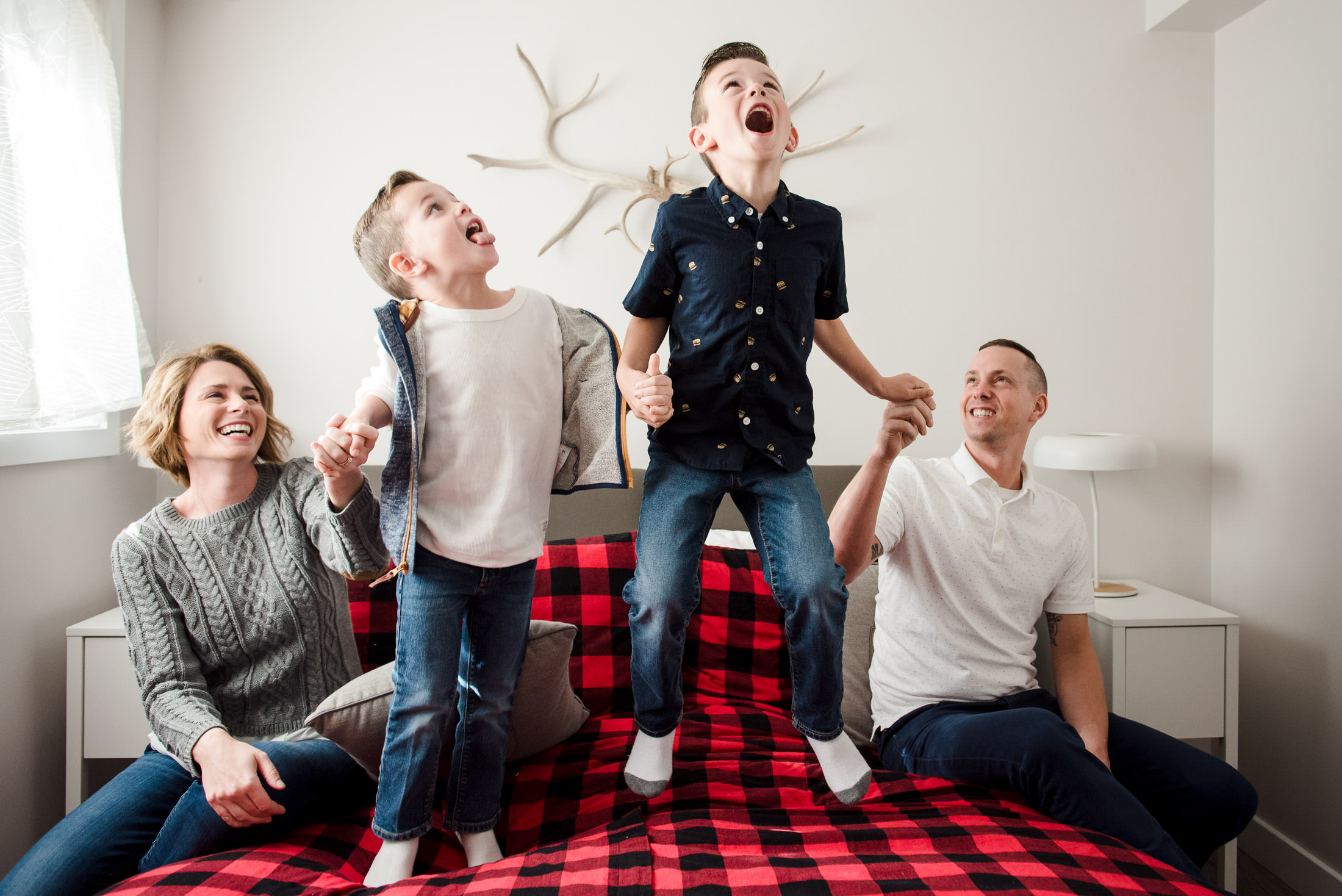 Kids jump on the bed during an Edmonton family photo session