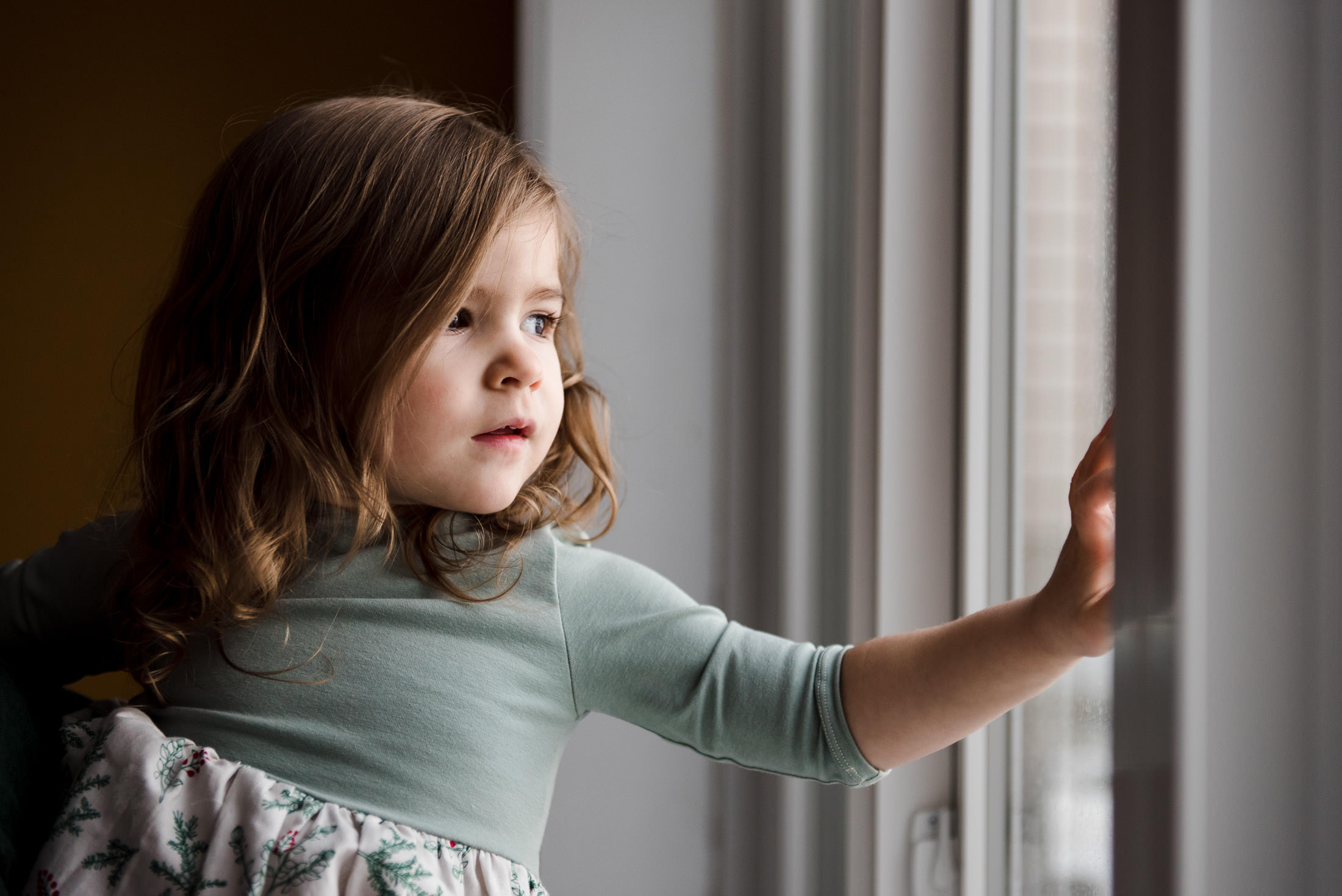 A little girl looks out a window