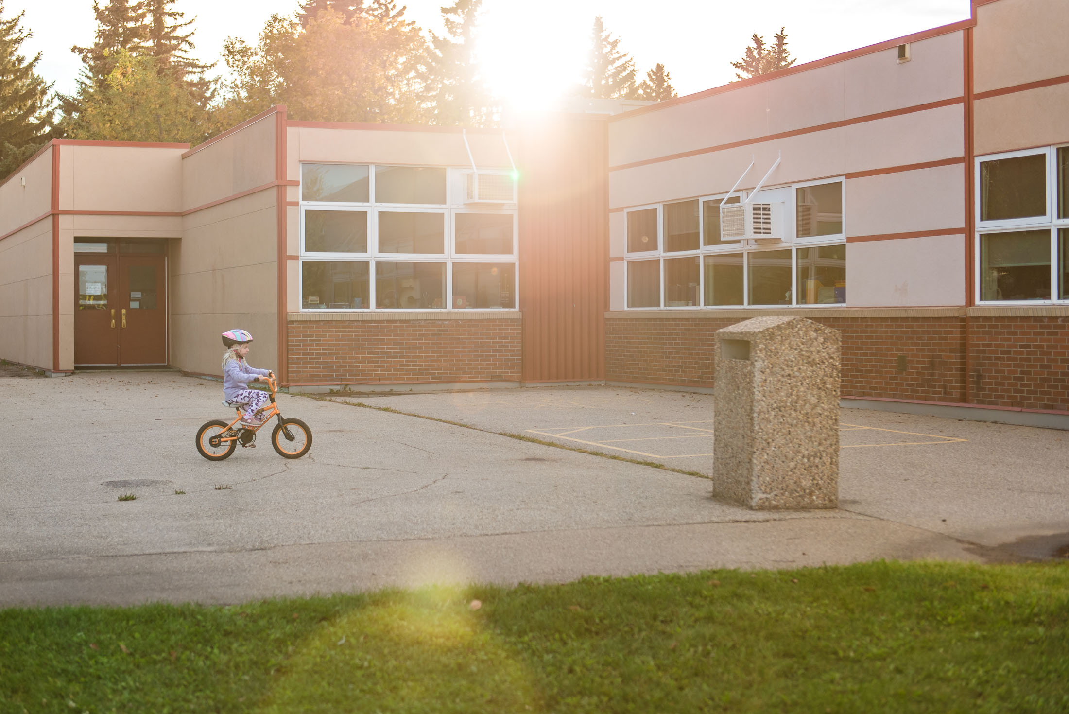 A girl rides her bike in the glowing Edmonton sun