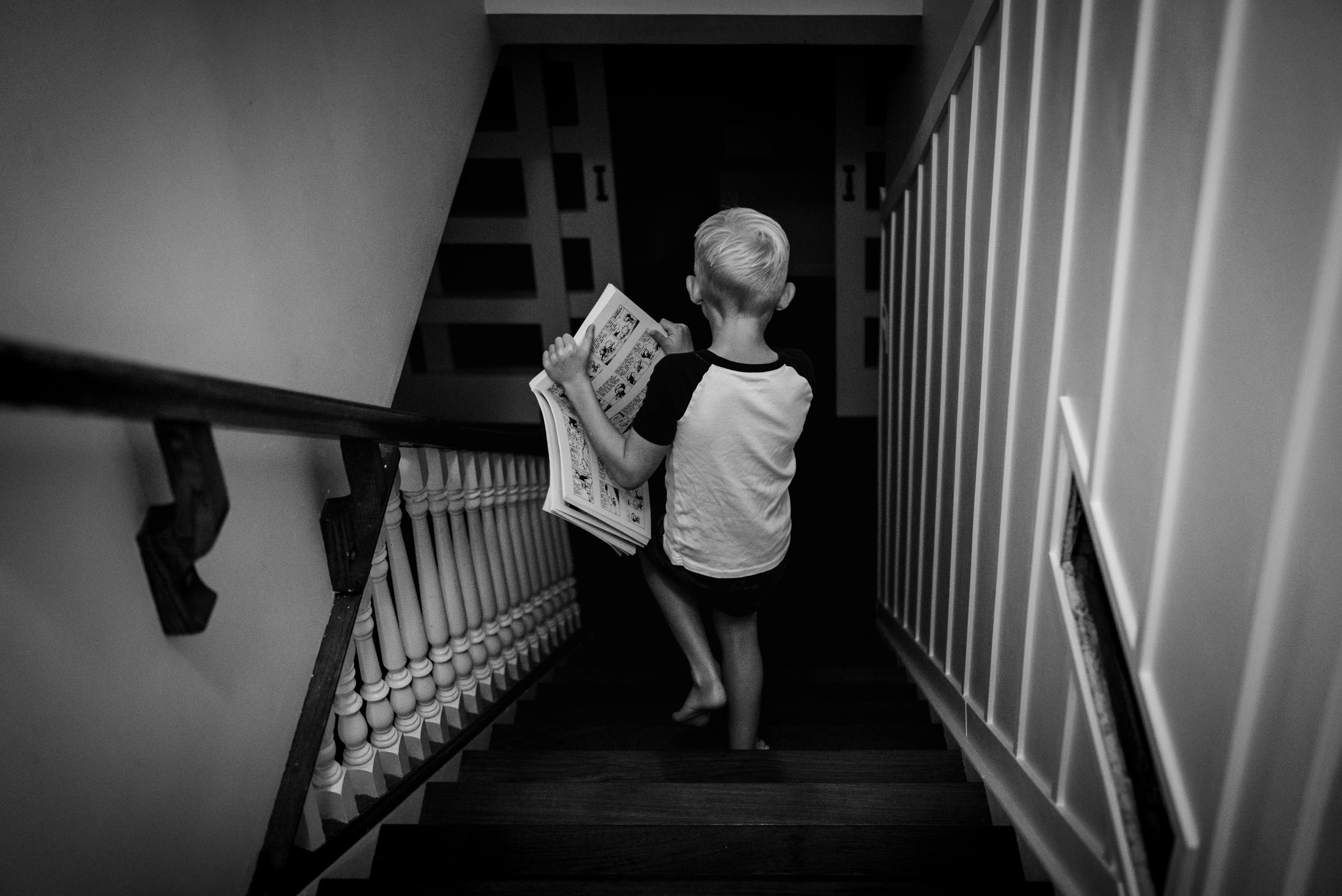 A little boy climbs down the stairs of his Edmonton home.