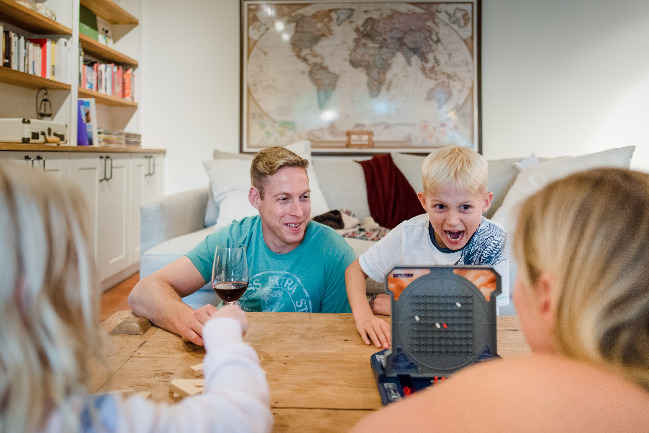 A family plays a board game during a family photo session in their Edmonton home.