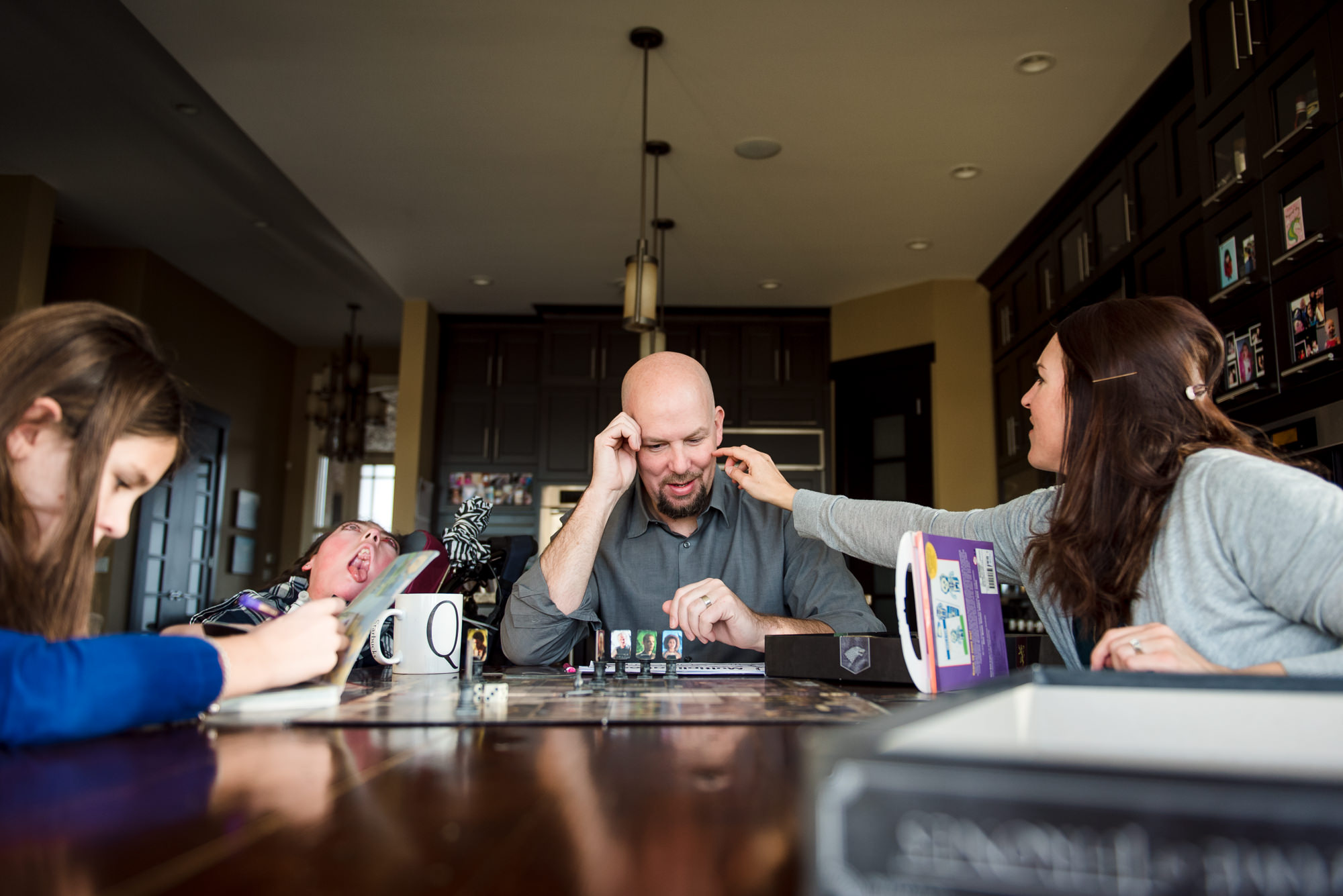 A family plays a board game as part of their documentary family photo session in their St. Albert home