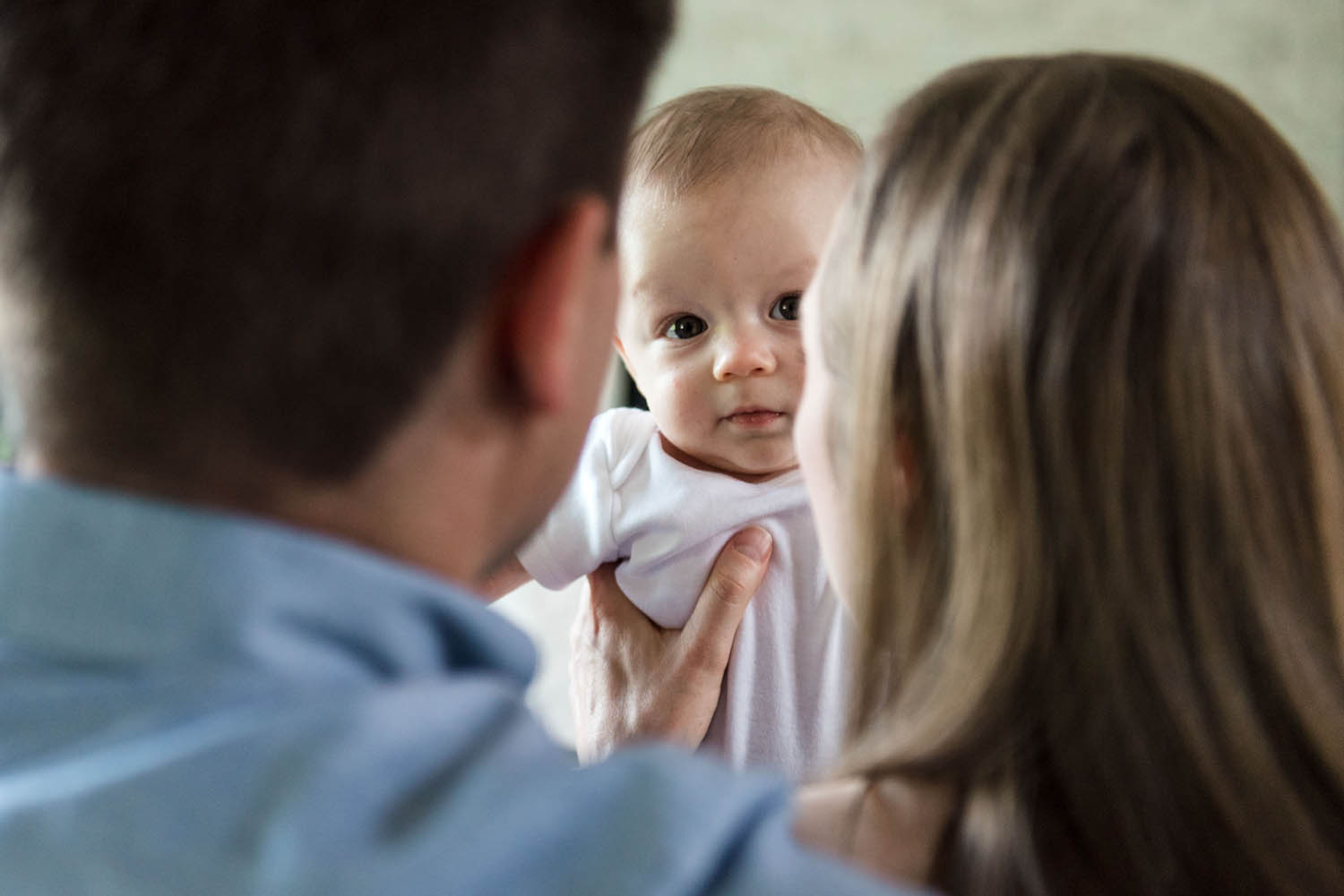 A baby looks at the camera during a 4 month old baby photo session in his Edmonton home. 