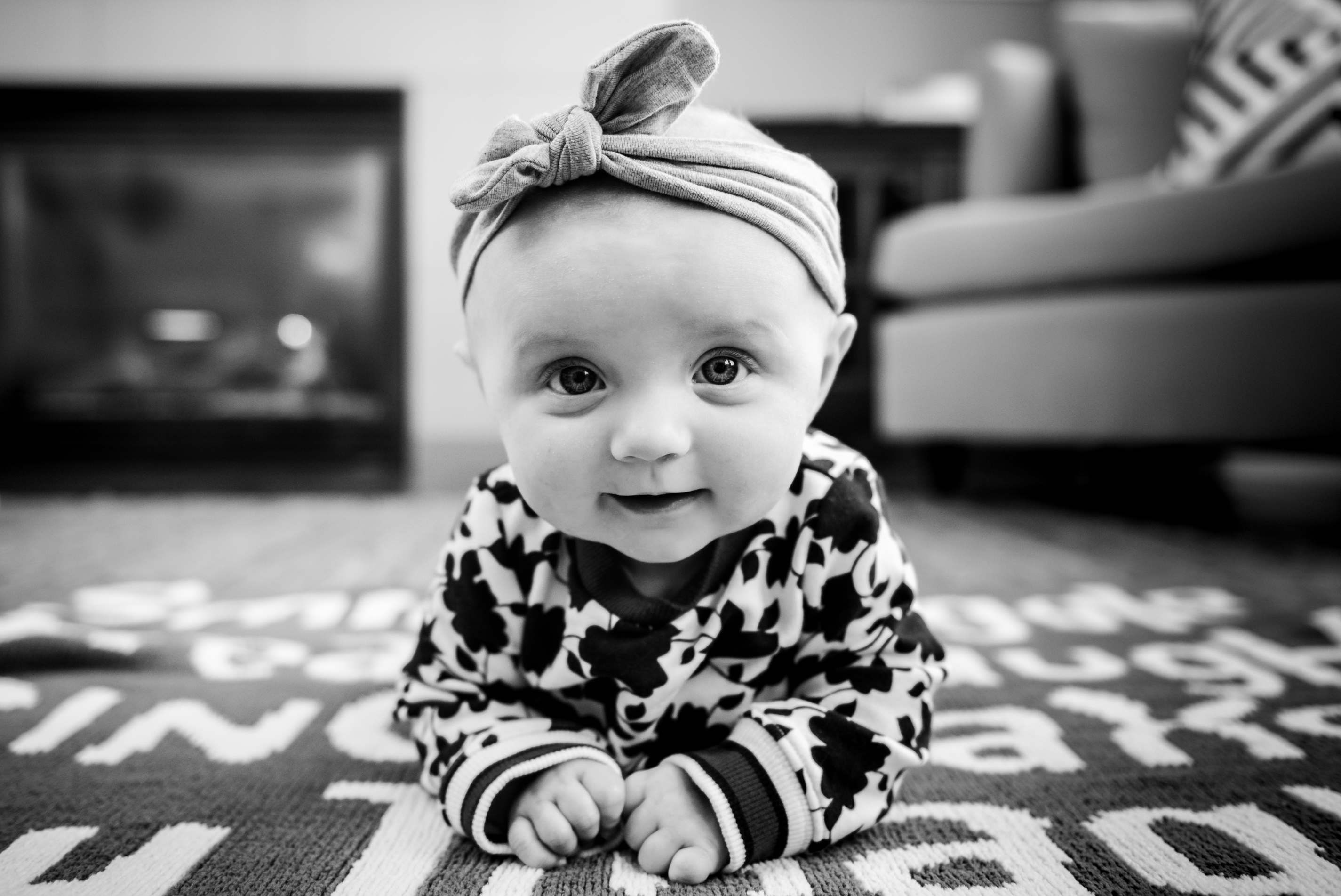 a 4 month old baby girl smiles during a baby photo shoot in sherwood park. 