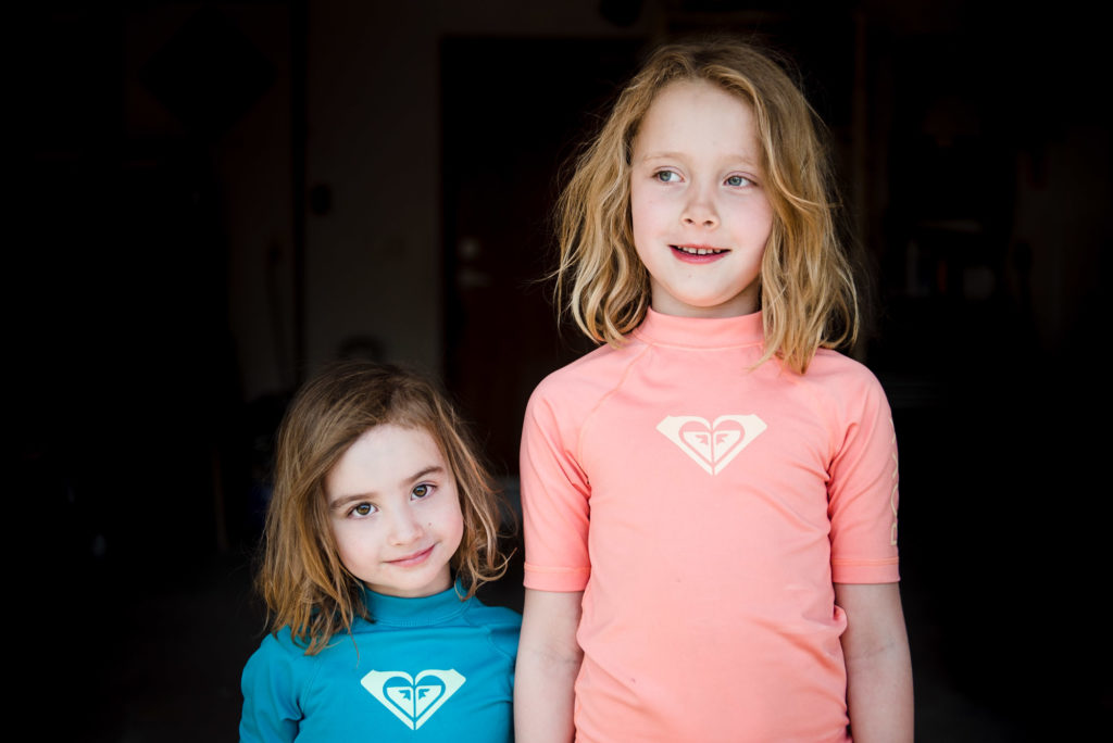 2 sisters stand for a portrait in their Sherwood park garage