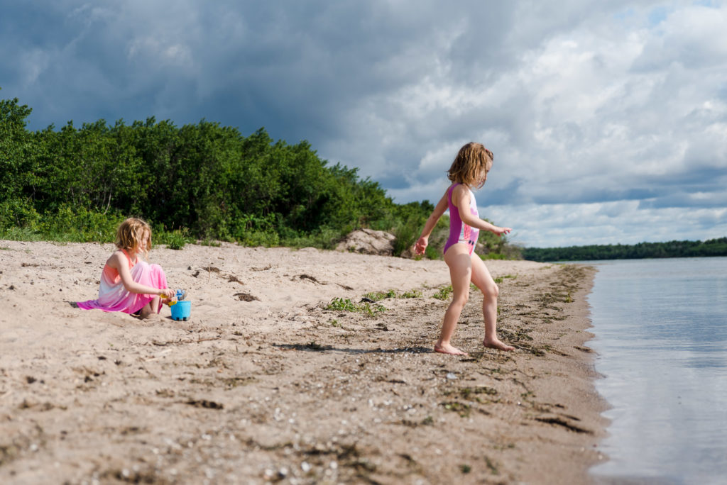 2 sisters play on a beach at Lac La Biche, Sir Winston Churchill Provincial Park