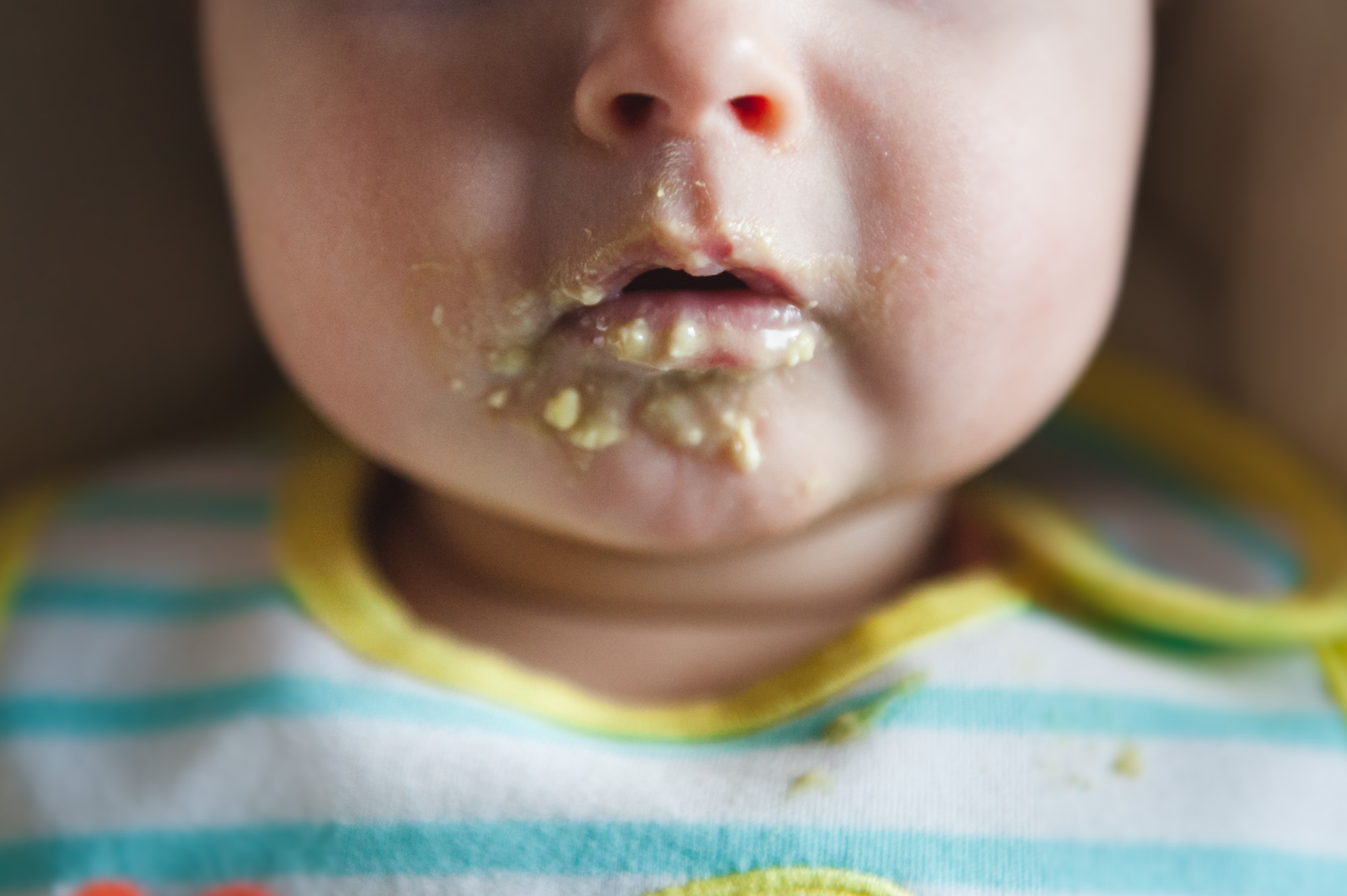 A close up of a baby's mouth after eating as part of her baby photo session in Edmonton