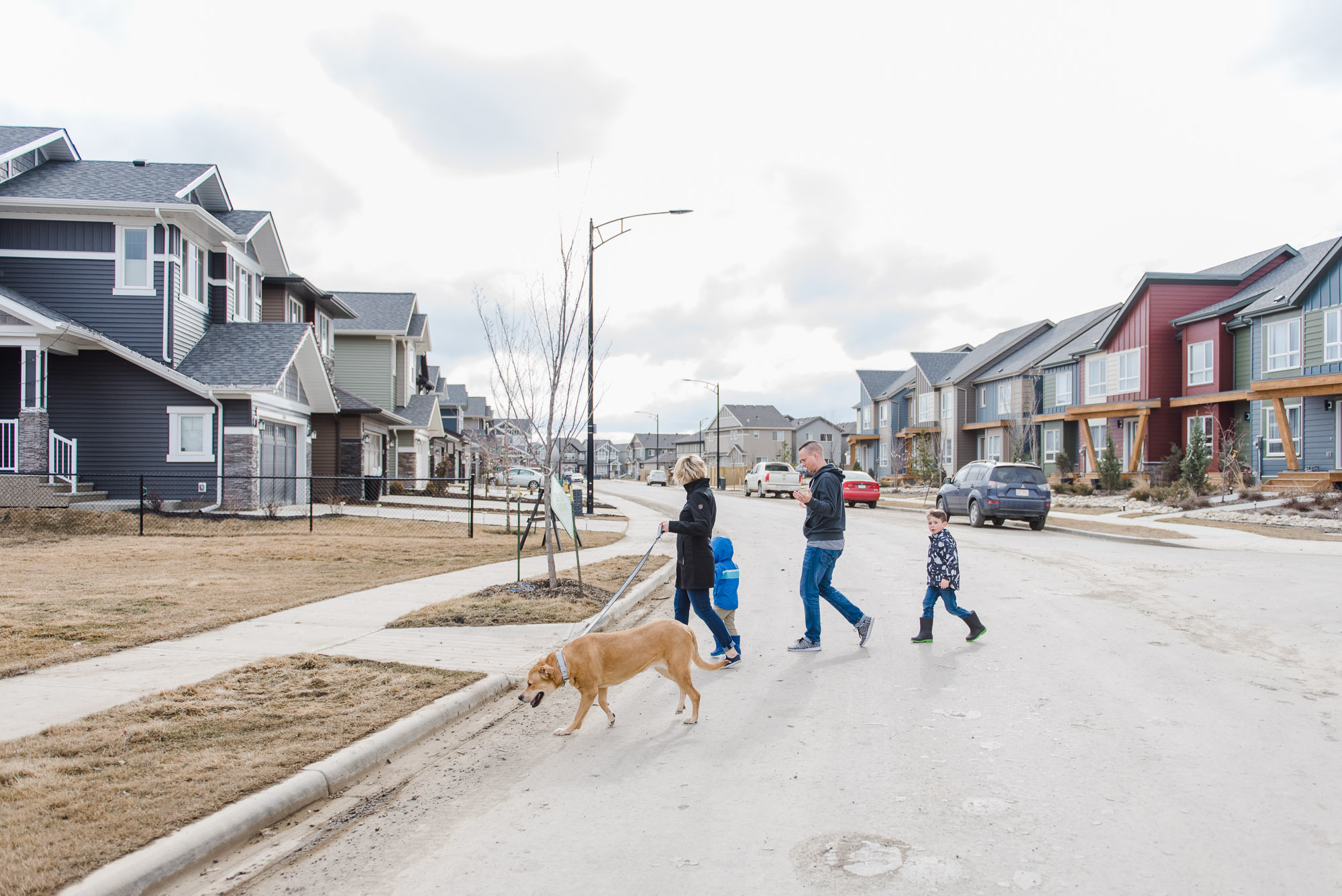 A family walks across the street in a new neighbourhood in Edmonton, Alberta