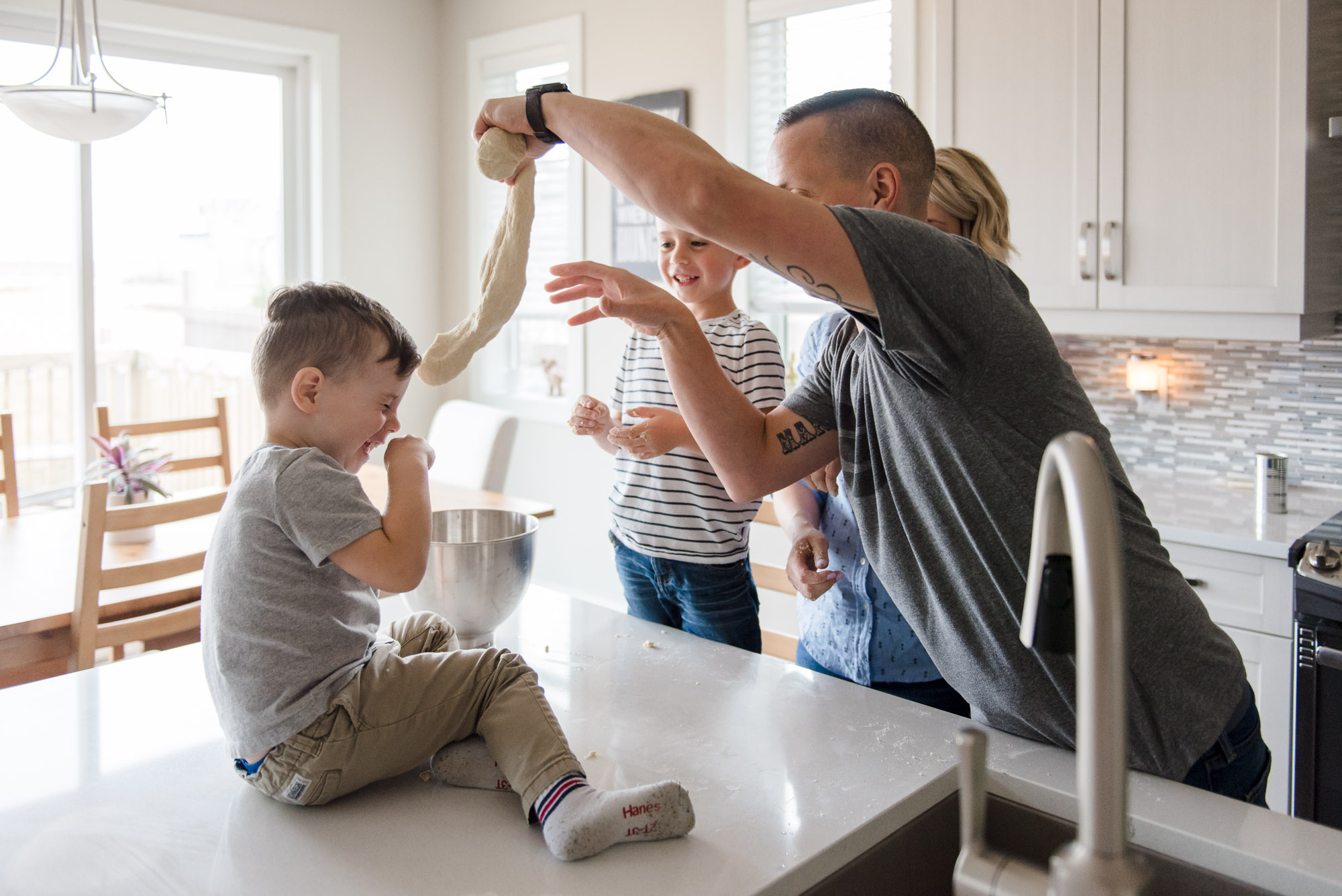 A family makes pizza together in their home in the Paisley neighbourhood of Edmonton, Alberta