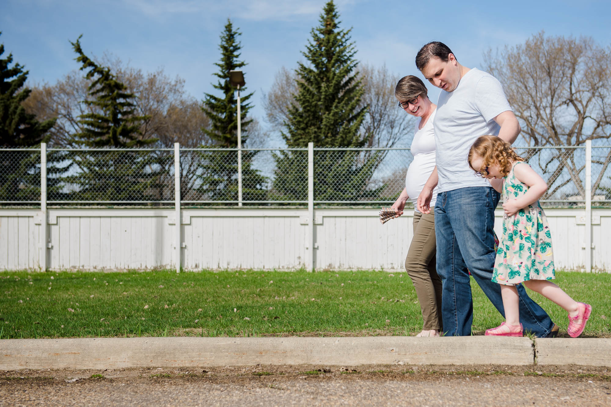 A family walks in Edmonton during their maternity photo session