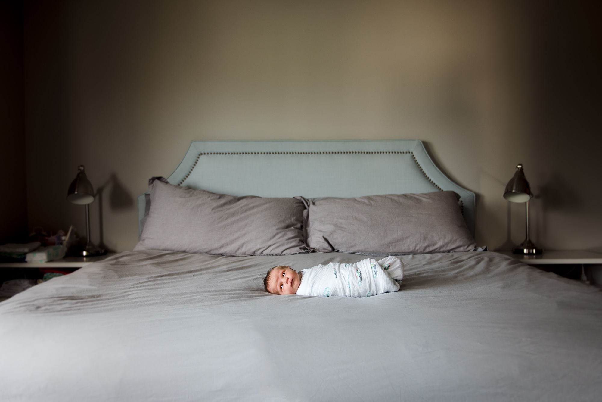 A newborn baby girl on a bed by Sherwood Park Newborn photographer Fiddle Leaf Photography