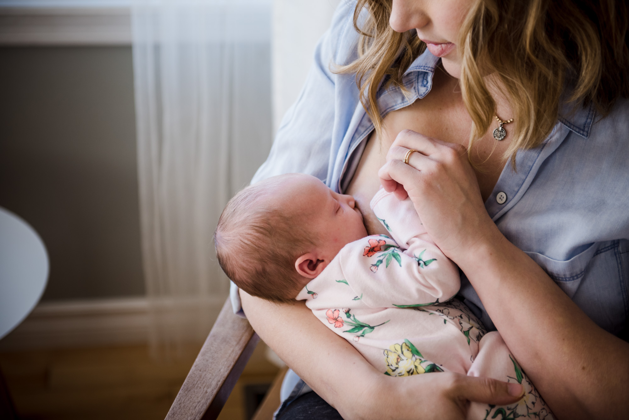 A mother breastfeeds her newborn baby in her Sherwood Park home