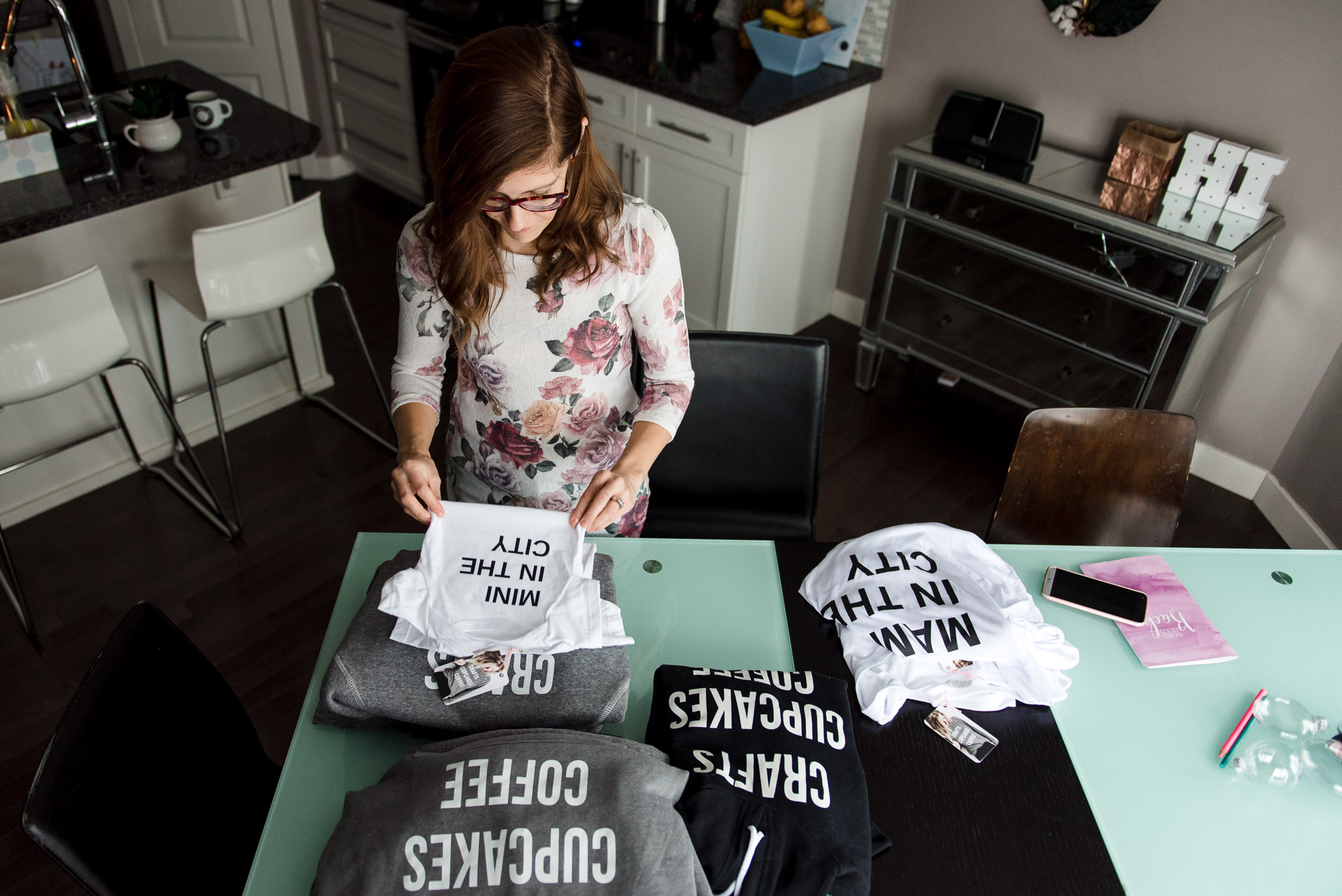 Nest in the City founder Jennifer Jones folds shirts as part of her crafts and cupcakes line of clothing