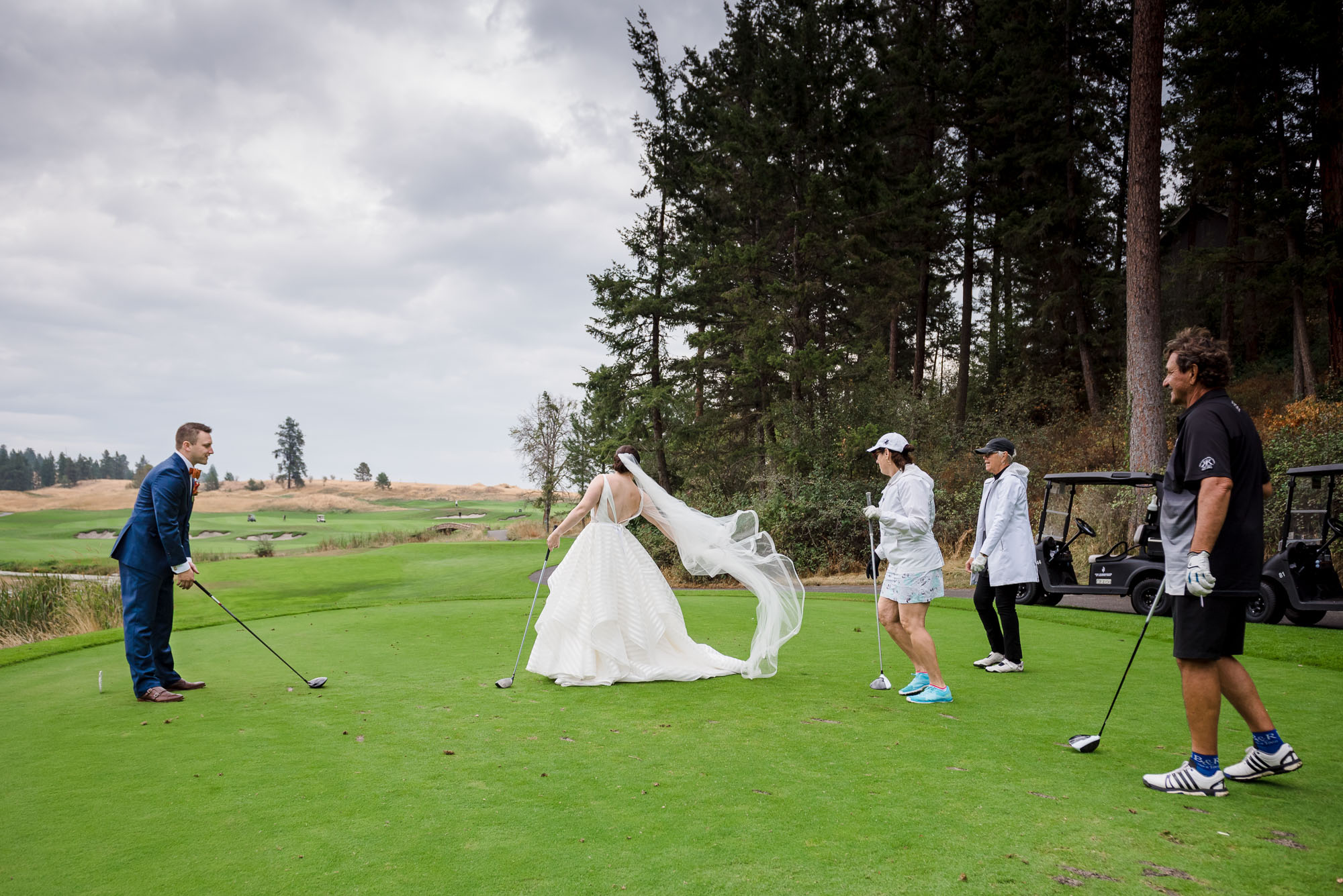 a bride and groom pose on the golf course during their wedding at Predator Ridge Resort. 