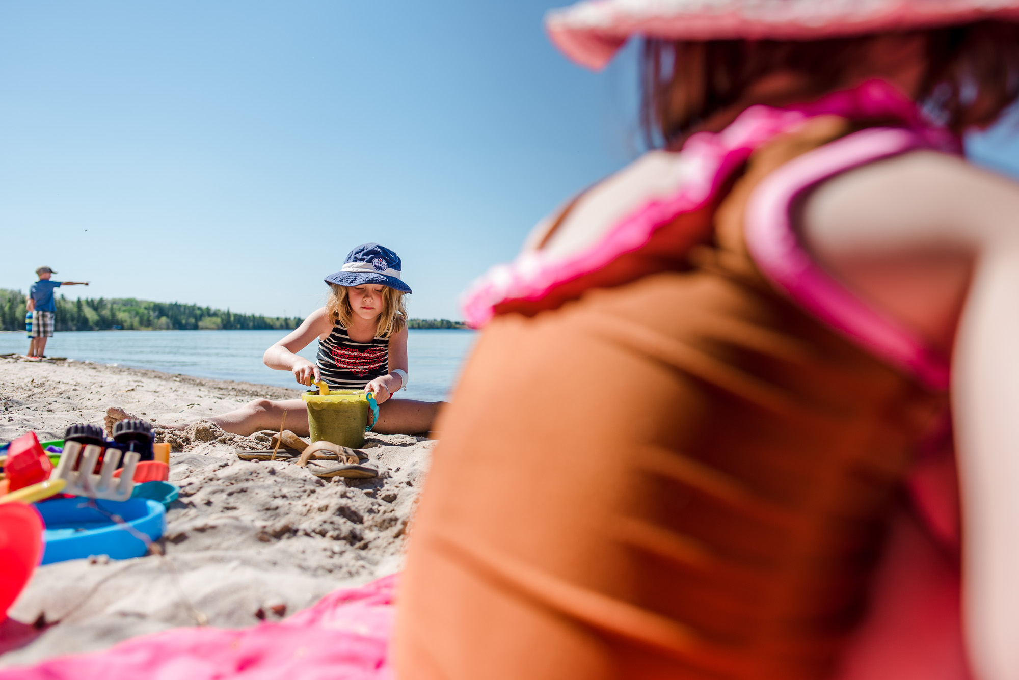 Sisters build sand castles at the beach in Cold Lake, Alberta