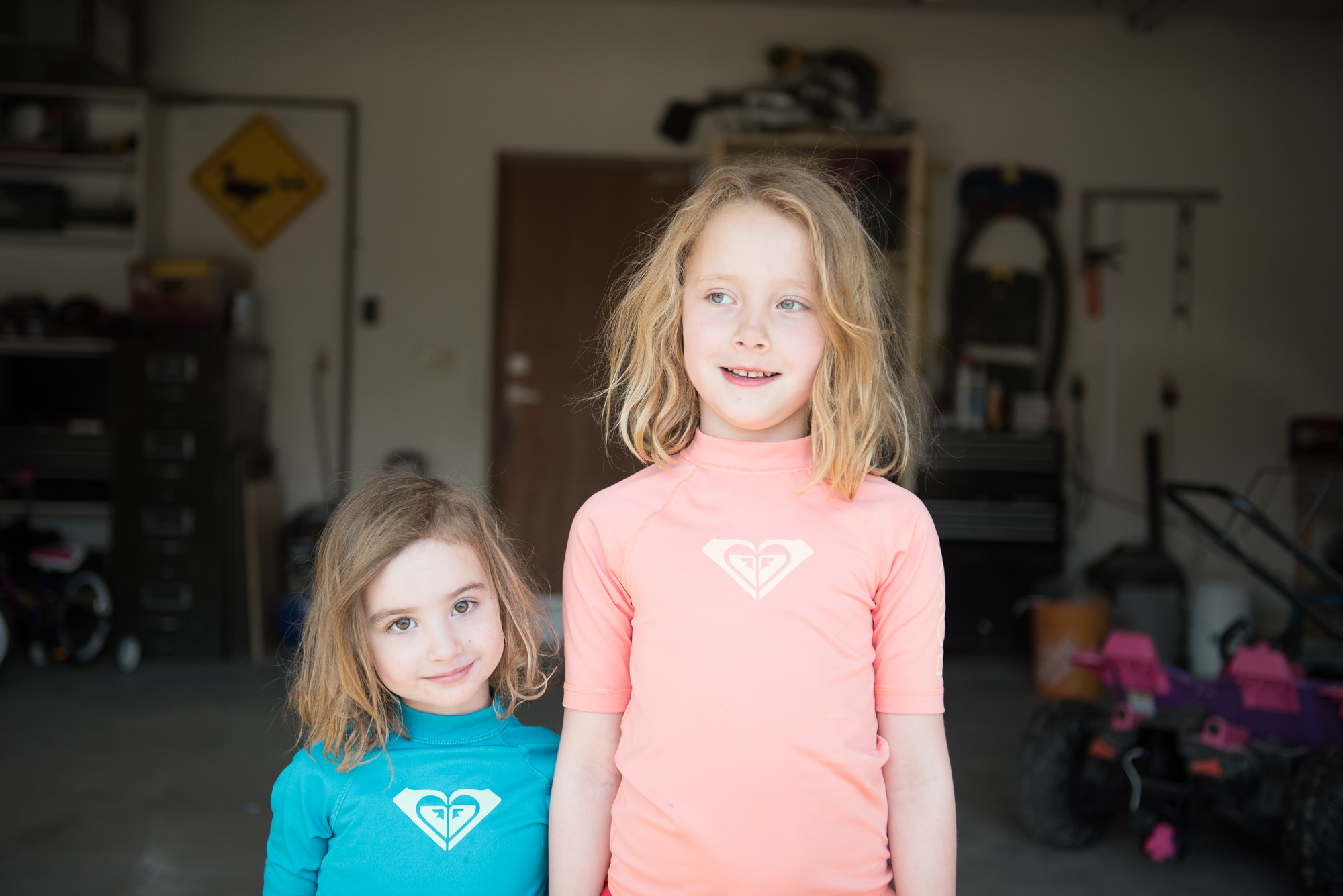 the straight out of camera, unedited, image of 2 sisters in garage light. 