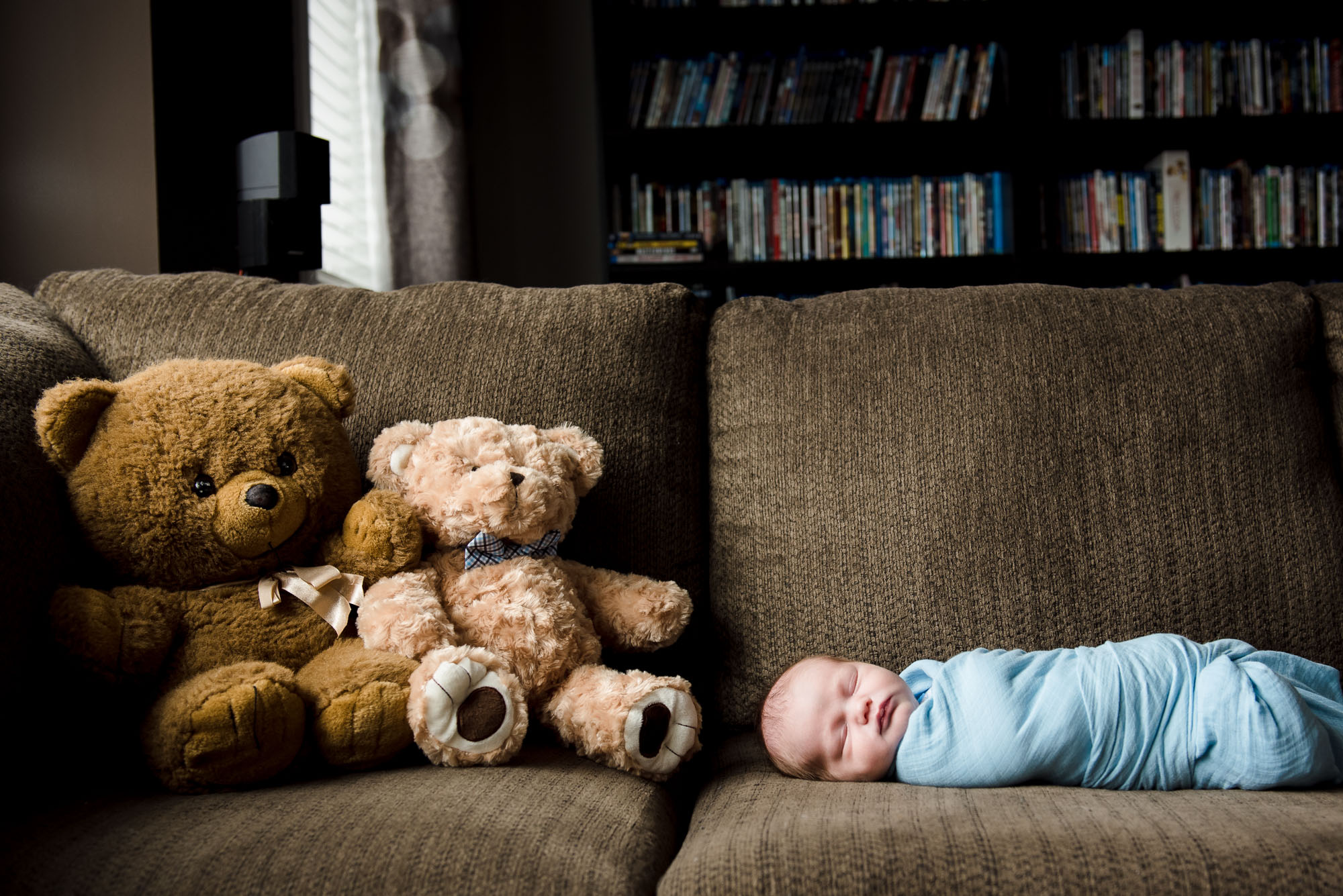 A baby lays next to vintage teddy bears during an Edmonton newborn photo session