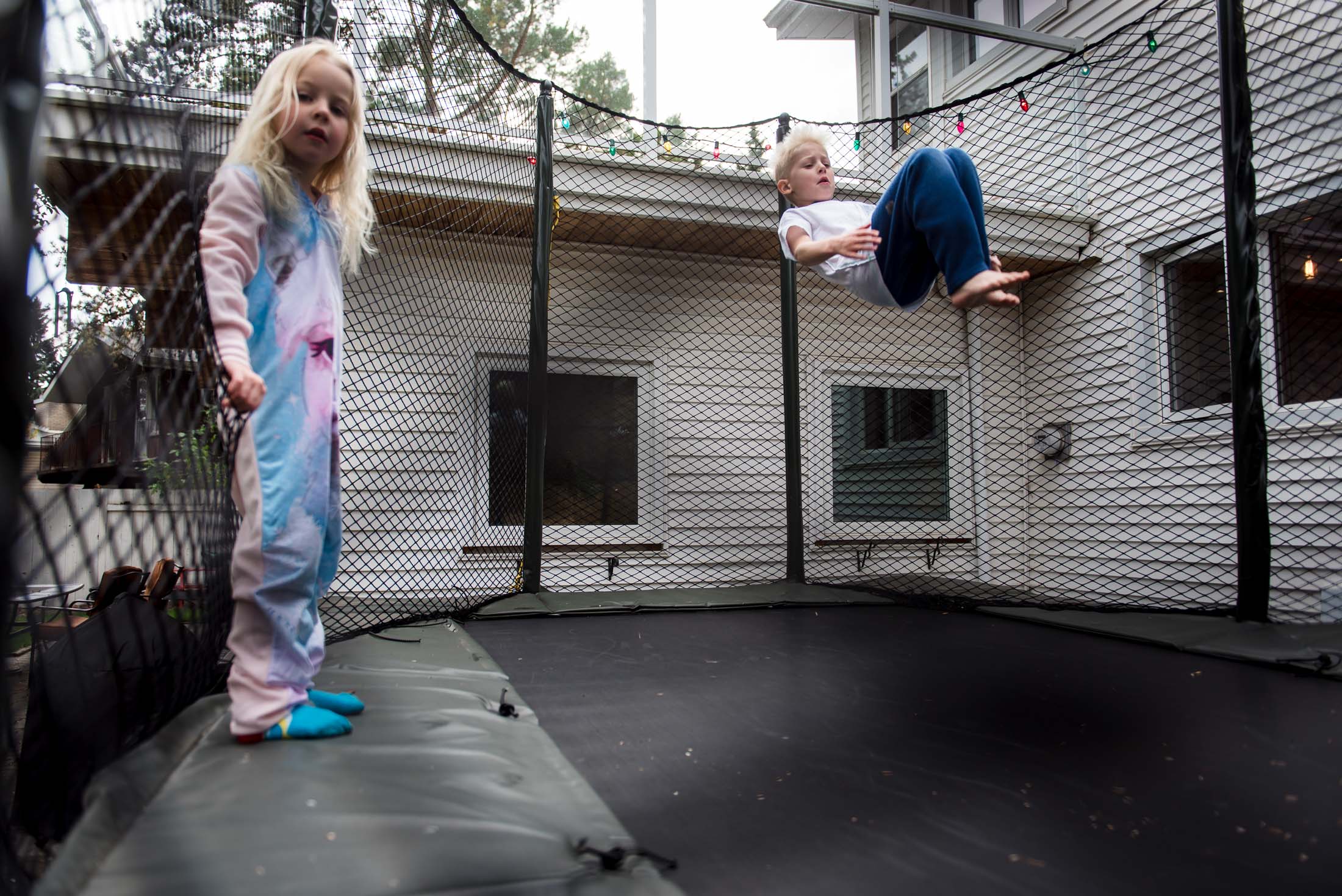 Kids jump on a trampoline in their Edmonton Backyard