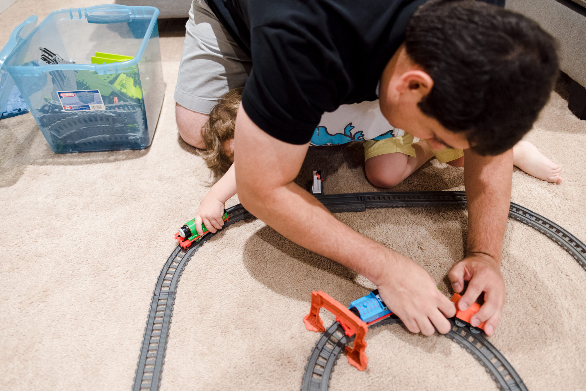 A little boy plays toys with his Dad during family photos by Fiddle Leaf Photography 