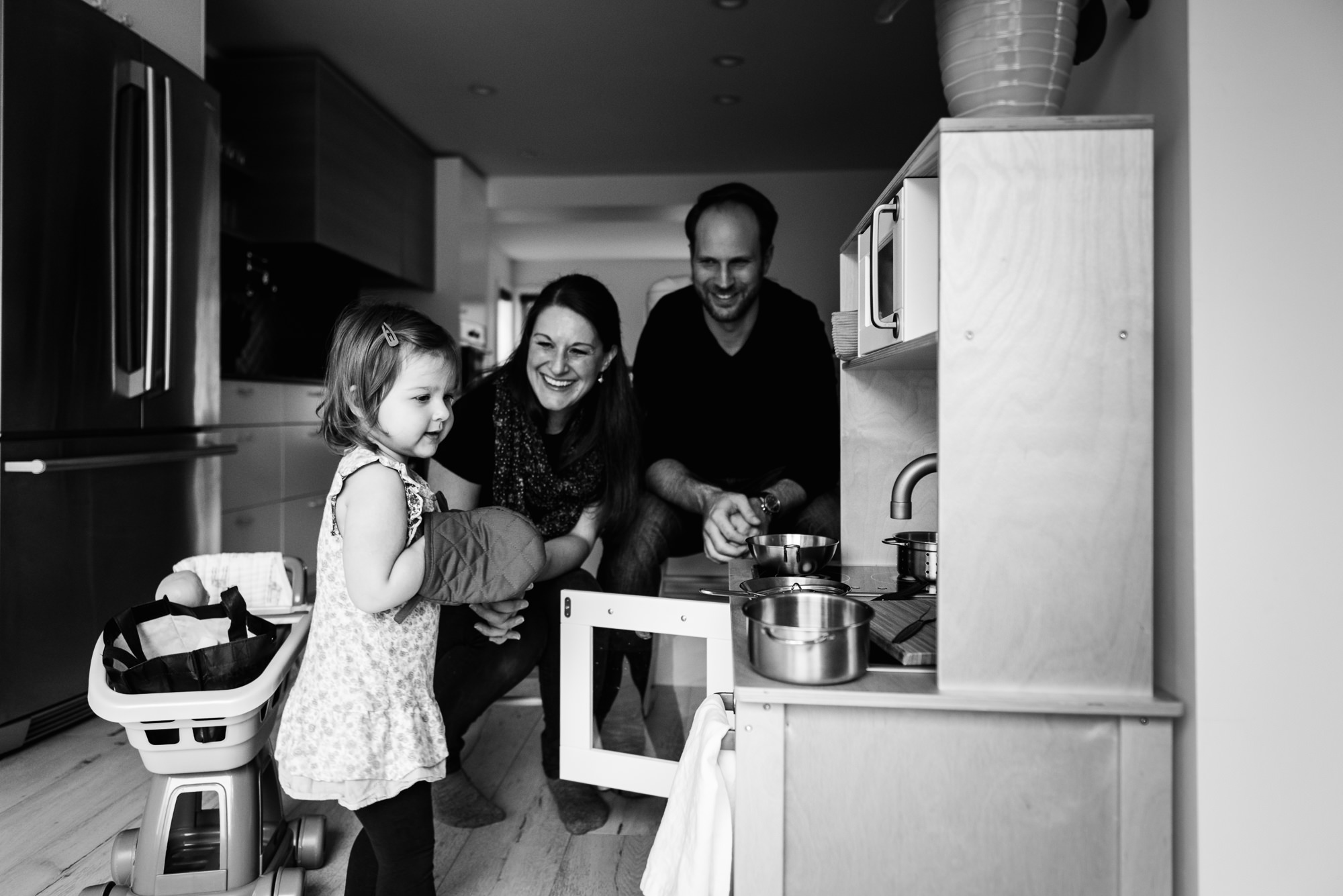 A family plays with a toy kitchen in the Glenora home as part of Edmonton Family Photography 