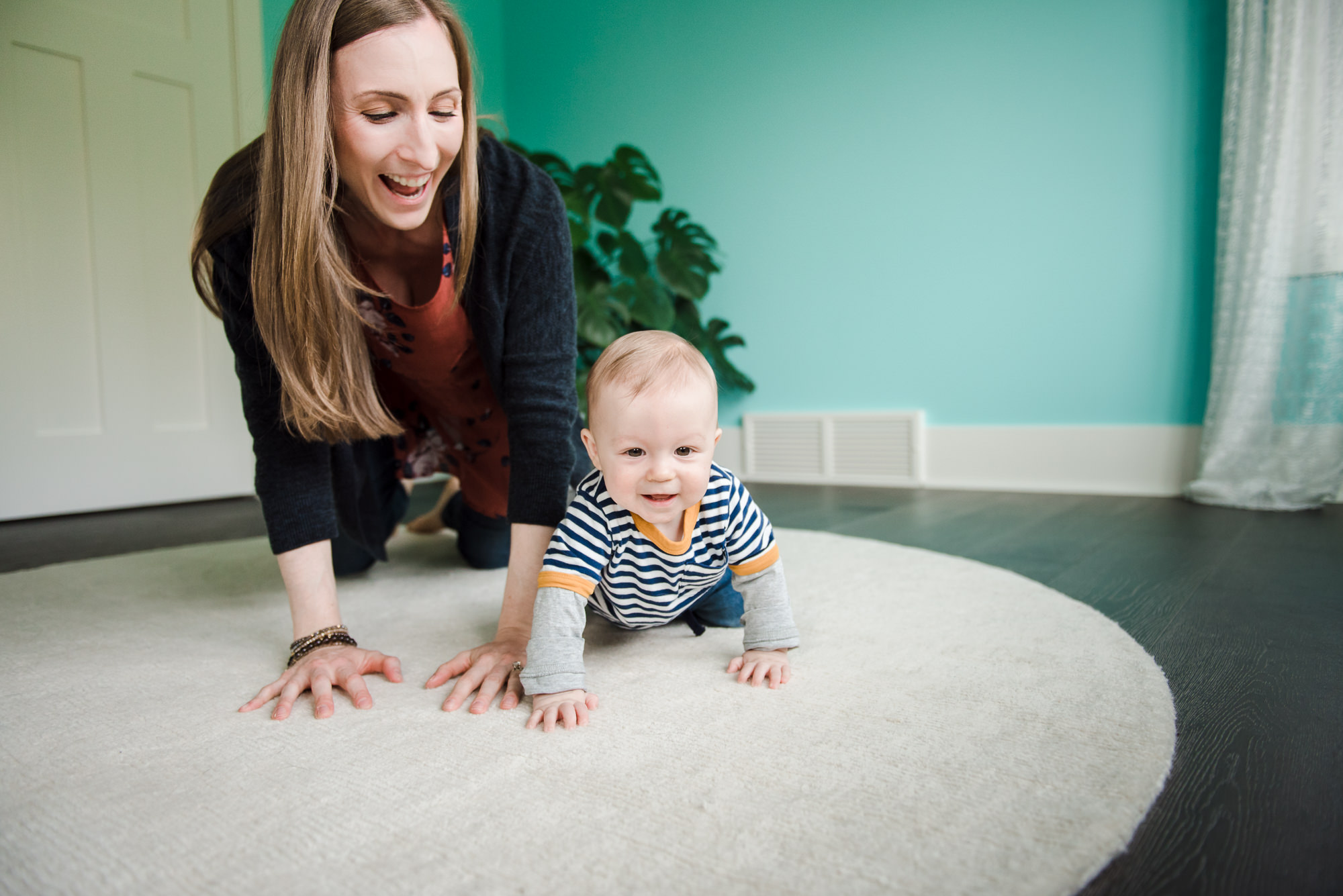 A mom crawls on the floor with her son in their west Edmonton home.