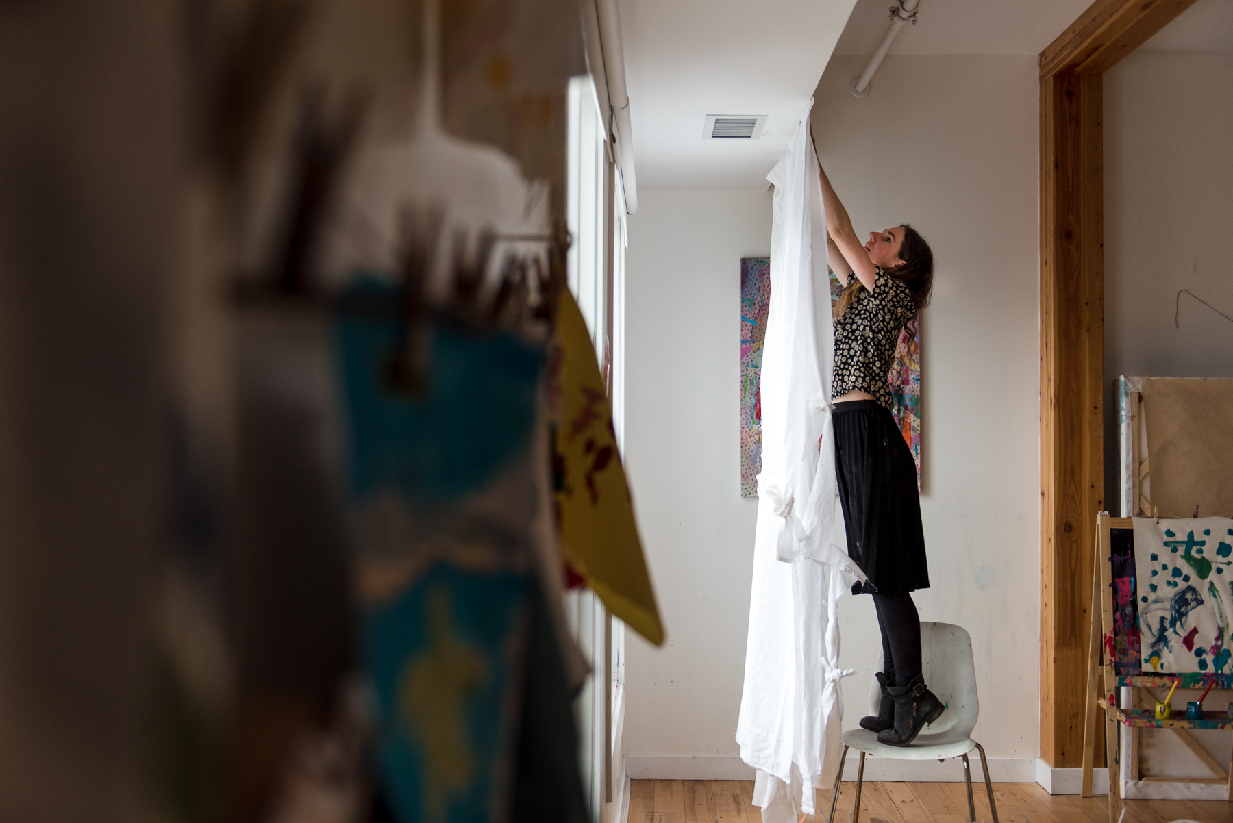 Alie Edwards hangs an art piece in her studio Creation Space in Edmonton 