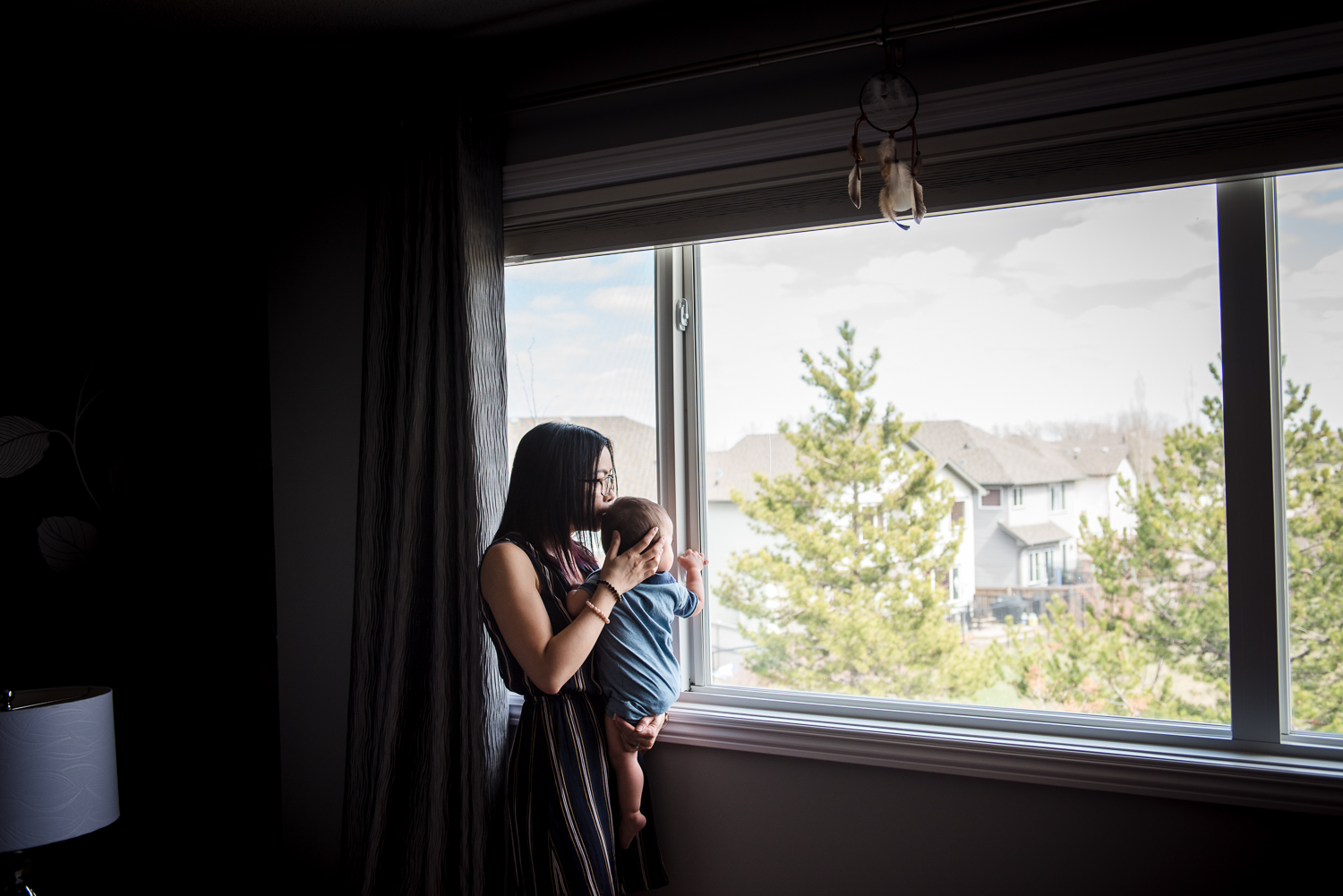 A mother and son stand near a window in their Sherwood Park home. 