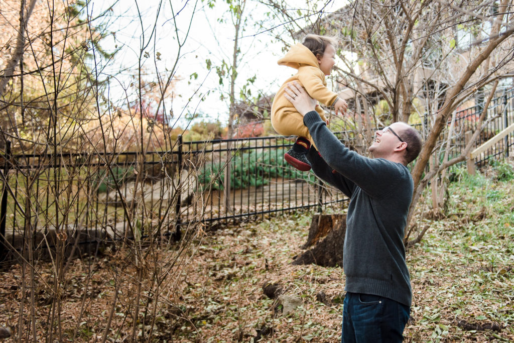 A Dad tosses his son in the air during a family photo session in their Edmonton yard