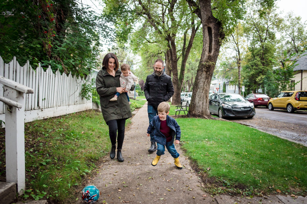 a family strolls down the street in their Edmonton neighbourhood