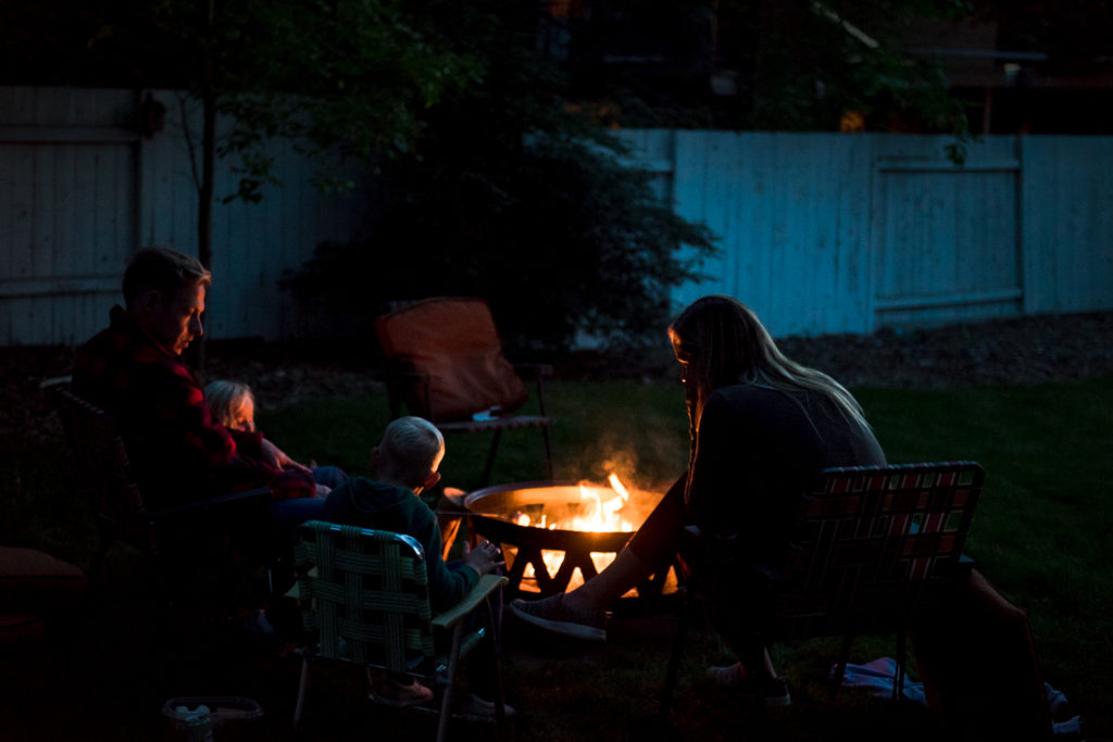 An Edmonton family has a campfire during a family photo session in their backyard