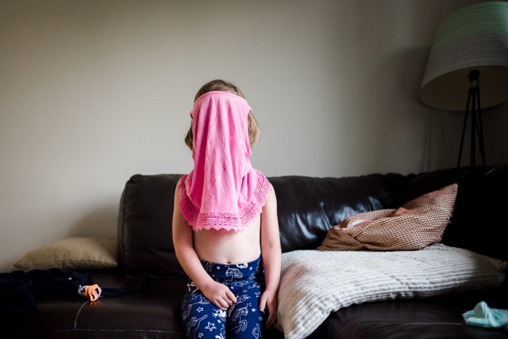 A girl sits in her edmonton living room while getting dressed for school. 

