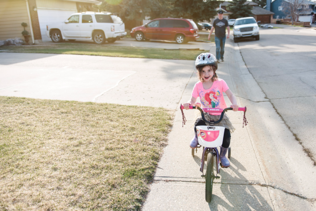 A litlte girl is riding a bike after attending Pedalheads day camp.